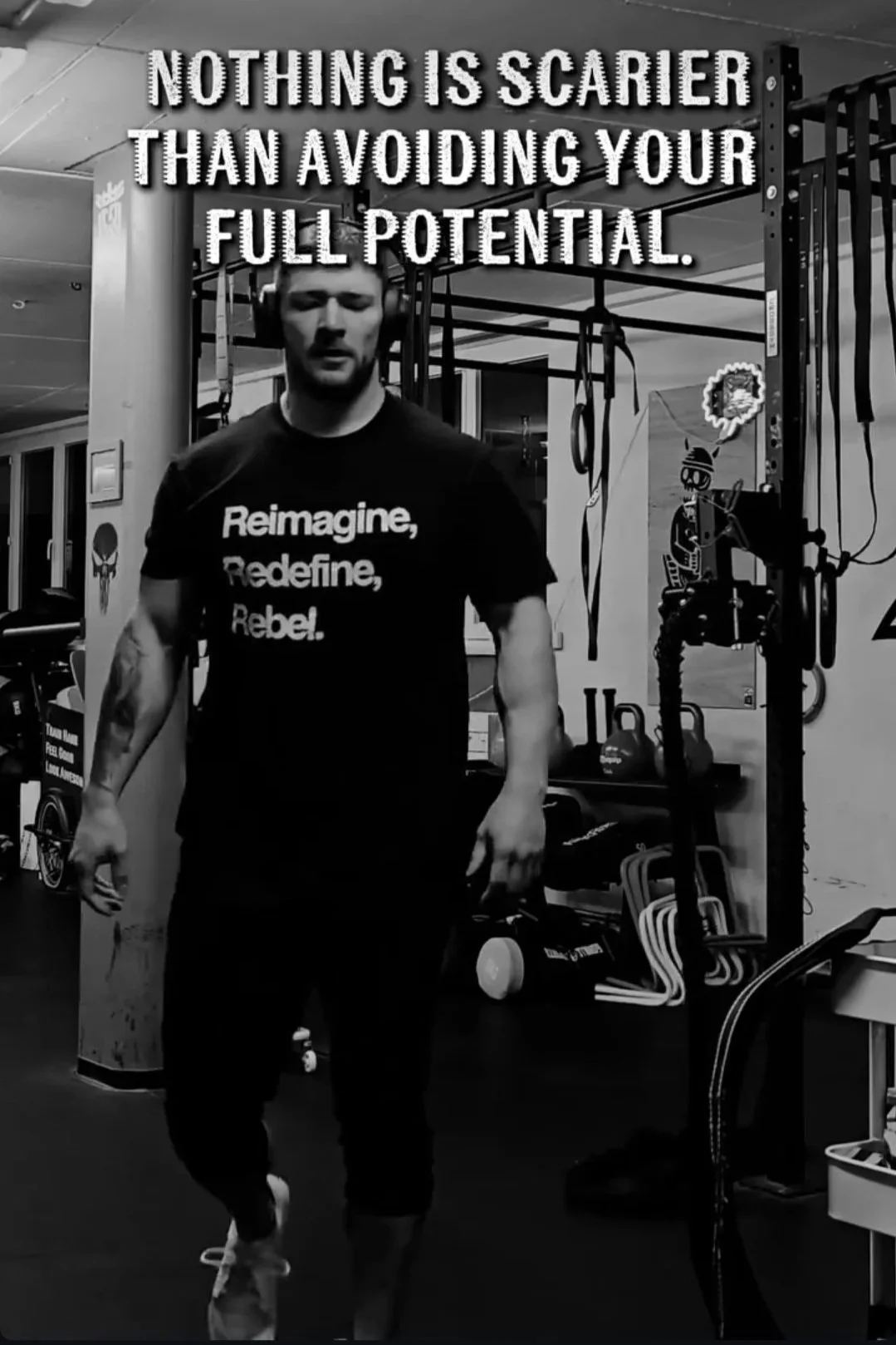 A man working out in a gym, wearing a t-shirt with the words "Reimagine, Redefine, Rebel" on it. There is a motivational quote on the wall above him that says "Nothing is scarier than avoiding your full potential." The background includes gym equipment like kettlebells and suspension straps.