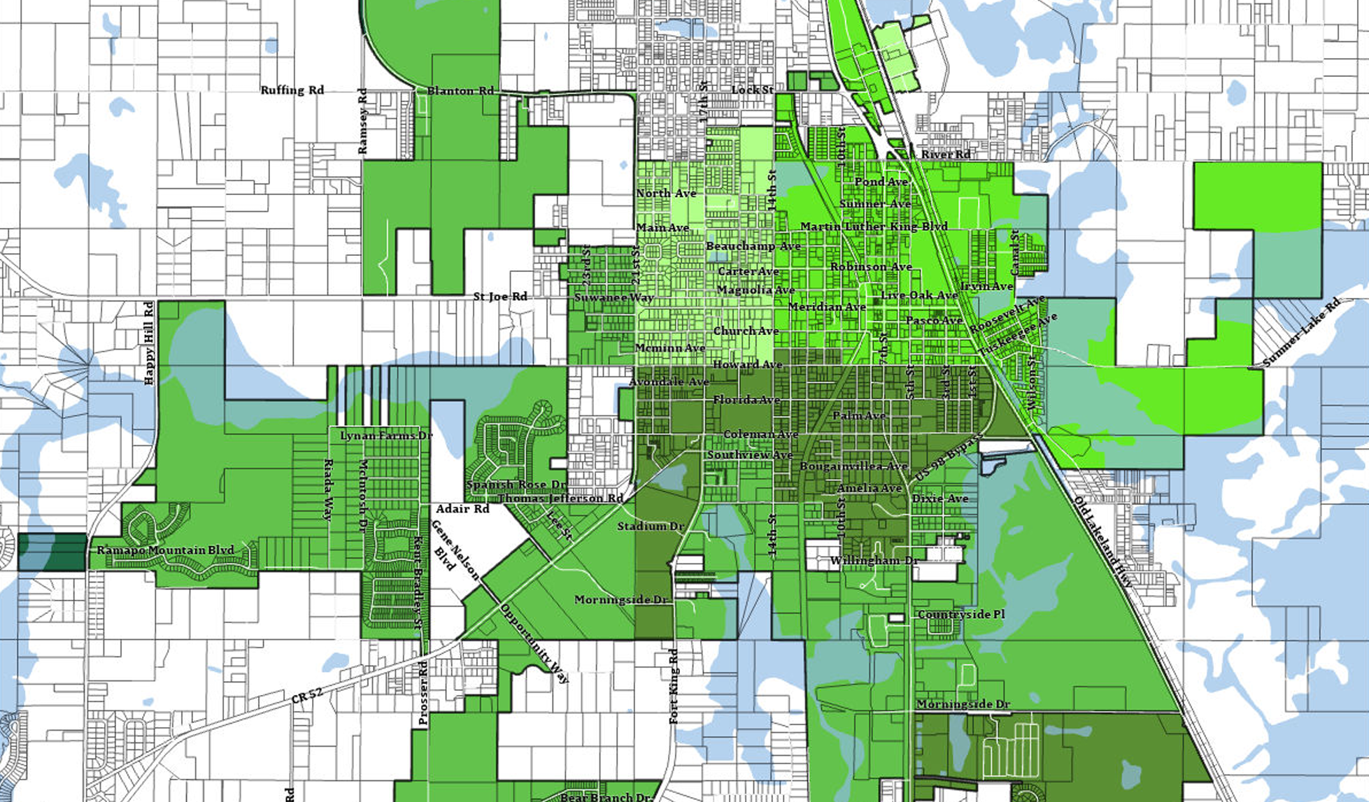 Map of a city with roads, parks, and water bodies, highlighting green areas.