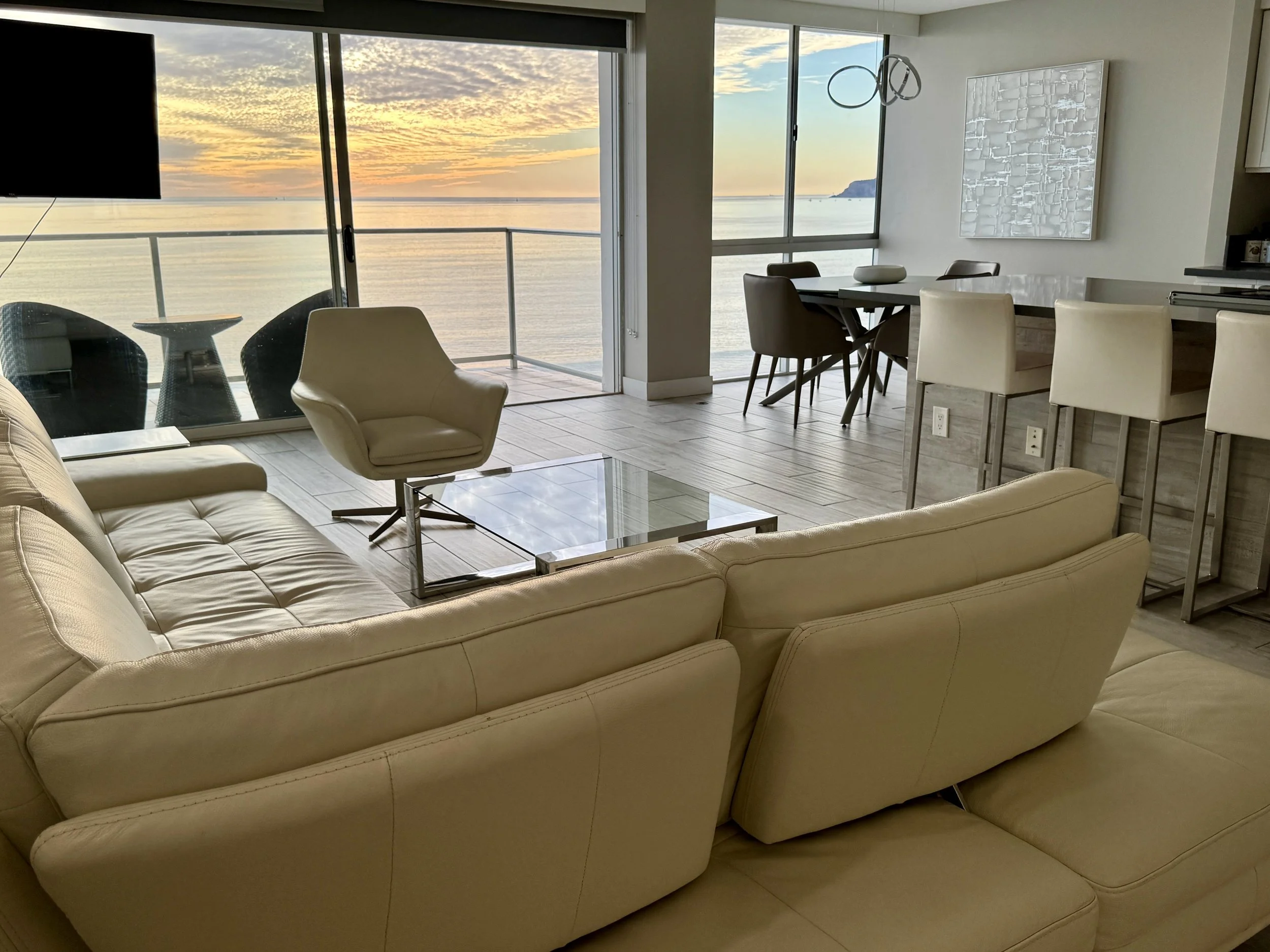 Salón con terraza, vistas al mar y puesta de sol en el apartamento amueblado Raíz Living Coronado