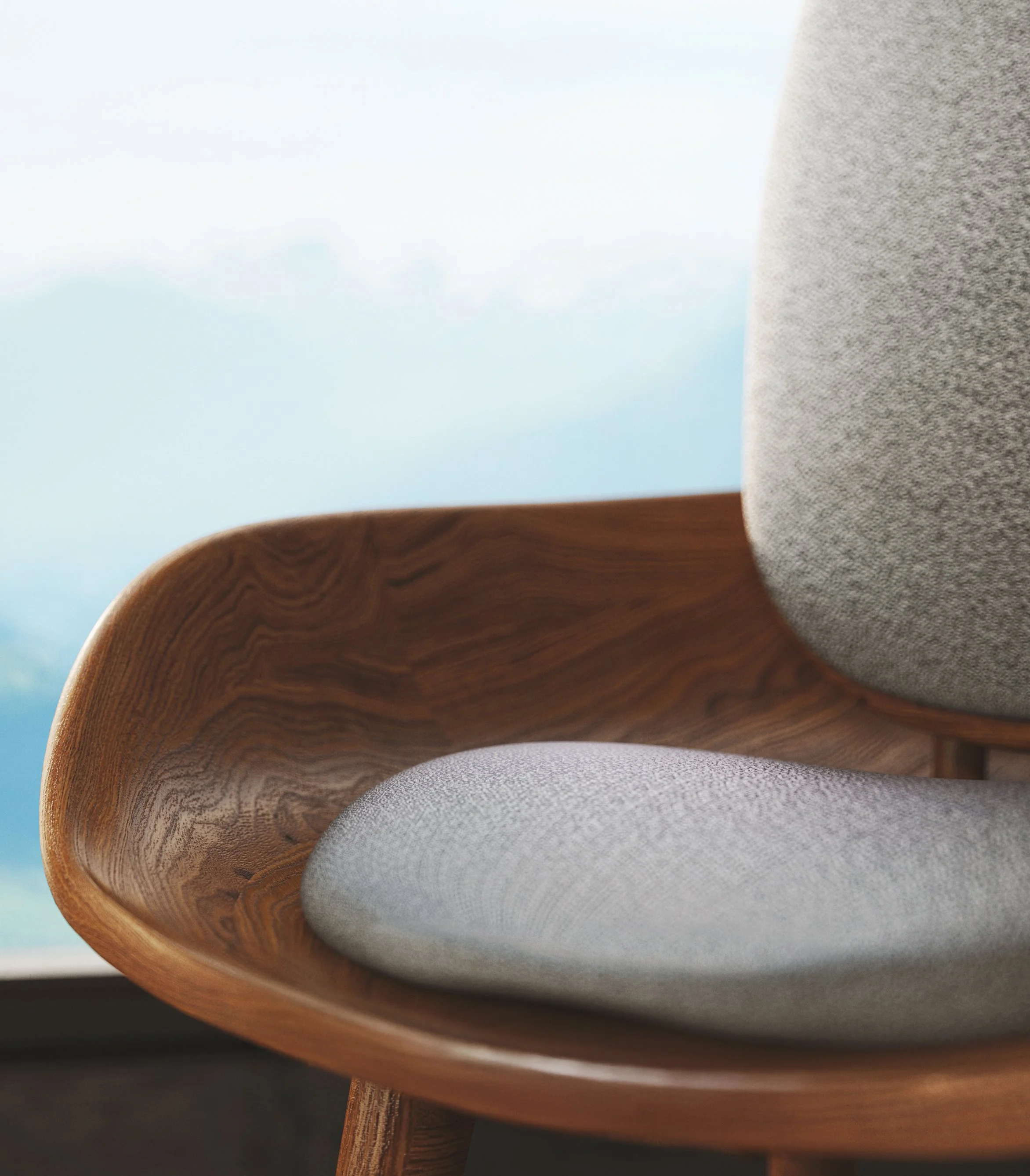 Close-up of a wooden table or furniture with a rounded edge and a gray cushioned item, with a blurred background of a light blue sky with some clouds.