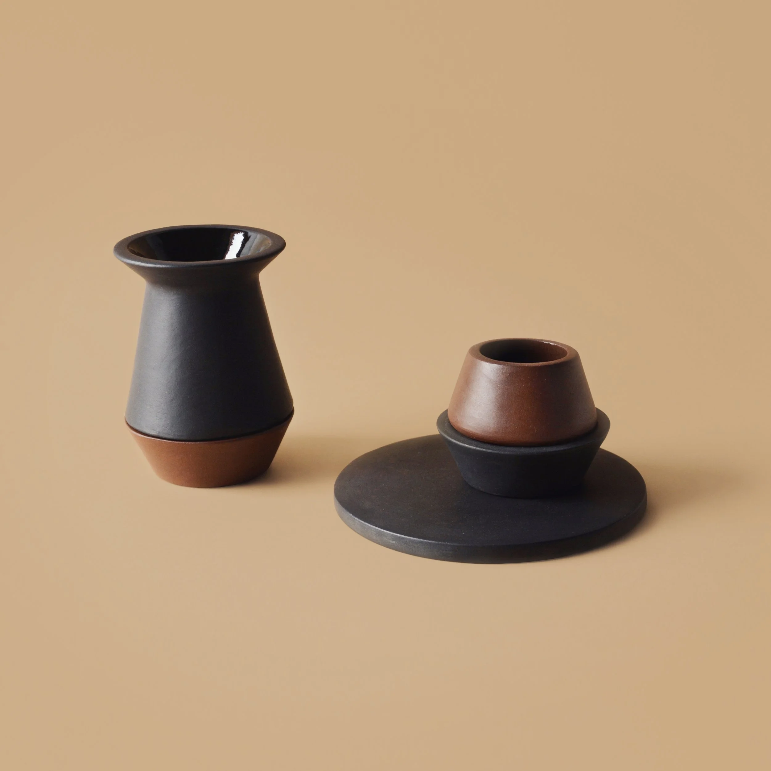 Three modern vases of varying heights and colors on a beige background.