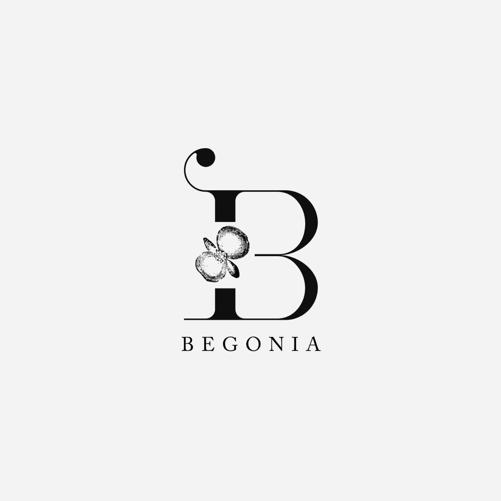 Stylized black letter B with a flower and clover graphics above and the word BEGONIA below, on a light gray background.