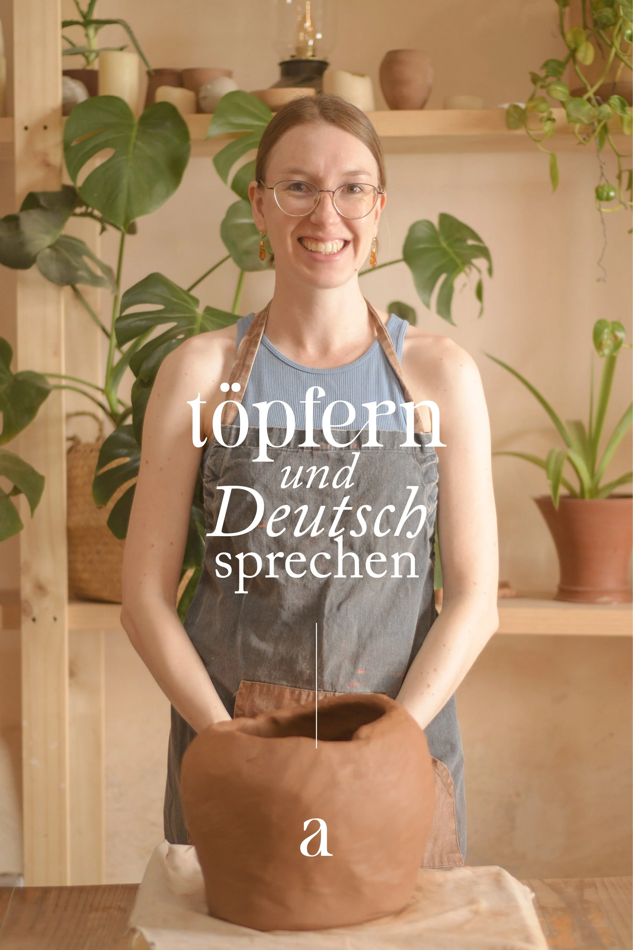A woman with glasses and earrings, smiling, wearing a apron, standing in front of shelves with plants and pottery, working on a pottery wheel with a large clay pot.
