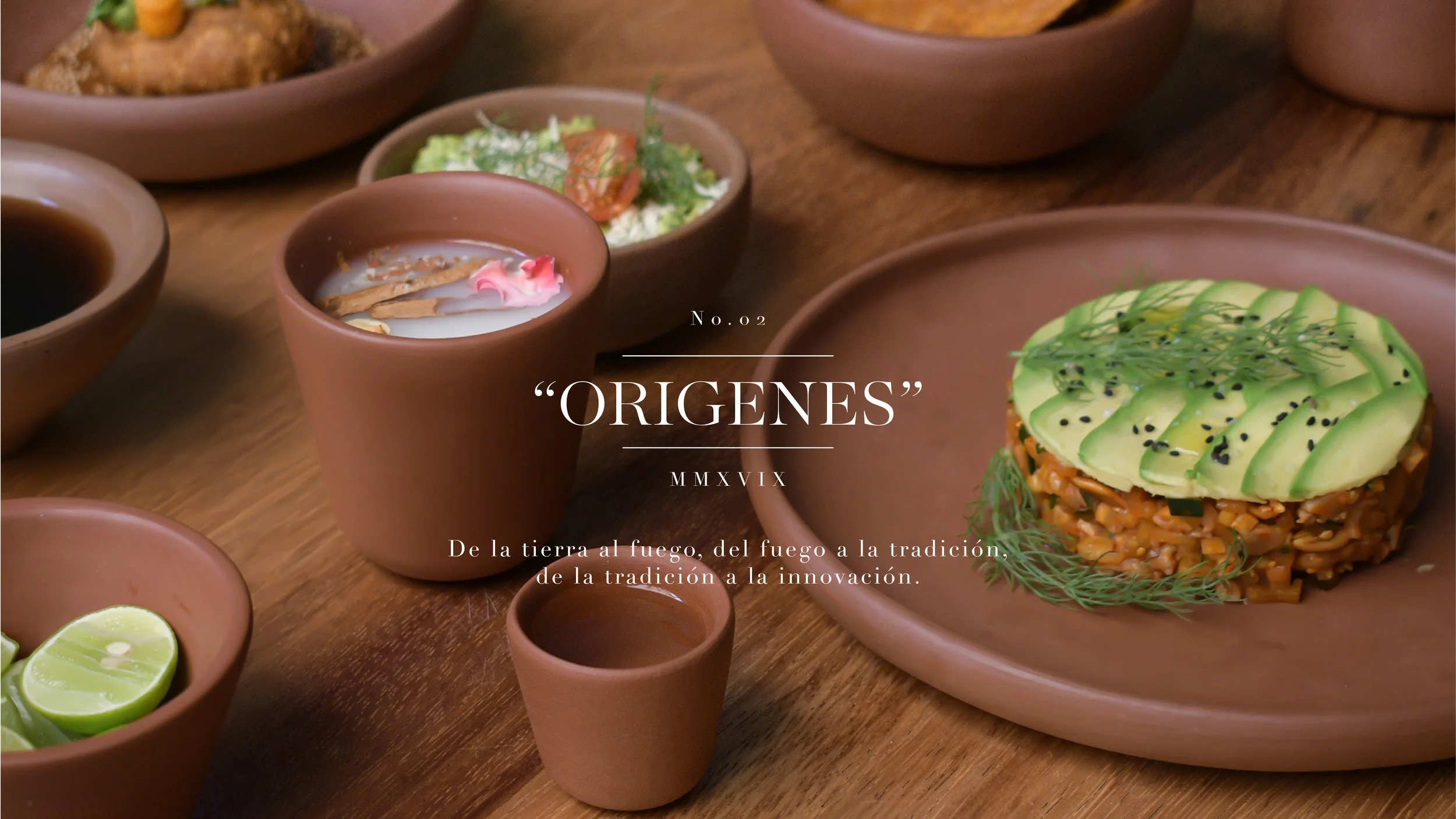 Various traditional Mexican dishes served on a wooden table, including a rice and avocado dish, lime wedges, and small bowls of sauces and condiments.