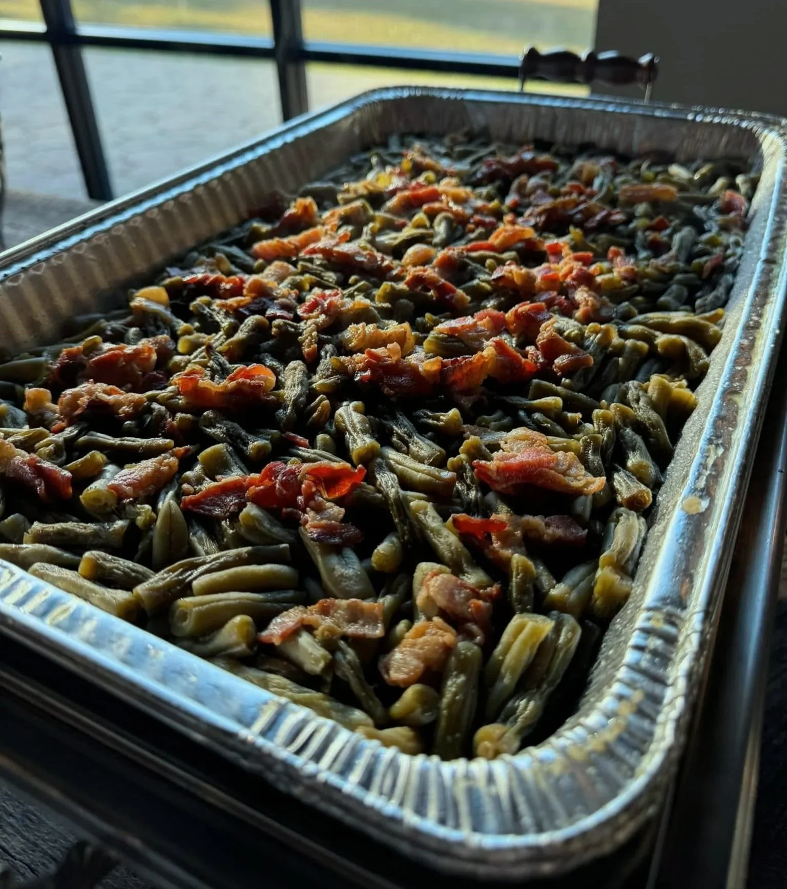 Tray of cooked green beans with bacon