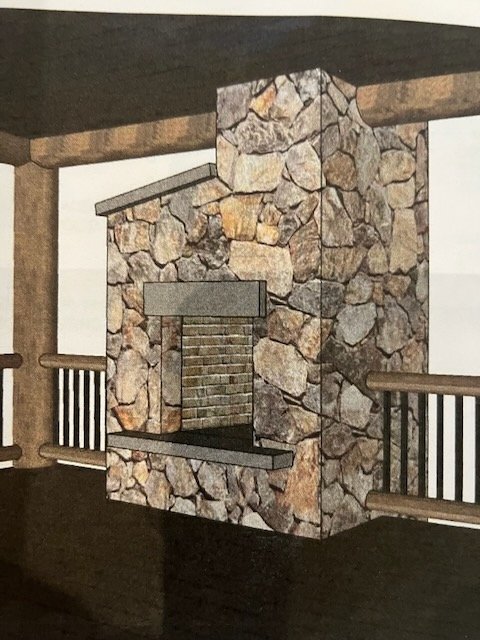 Stone fireplace with a brick interior and wooden mantel in a rustic room.