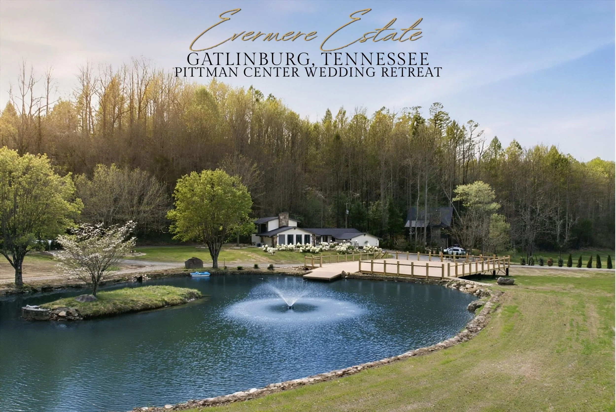 A scenic view of a pond with a fountain, surrounded by green grass and trees, with a wooden bridge and a white house in the background, located in Evermere Estate, Gatlinburg, Tennessee.