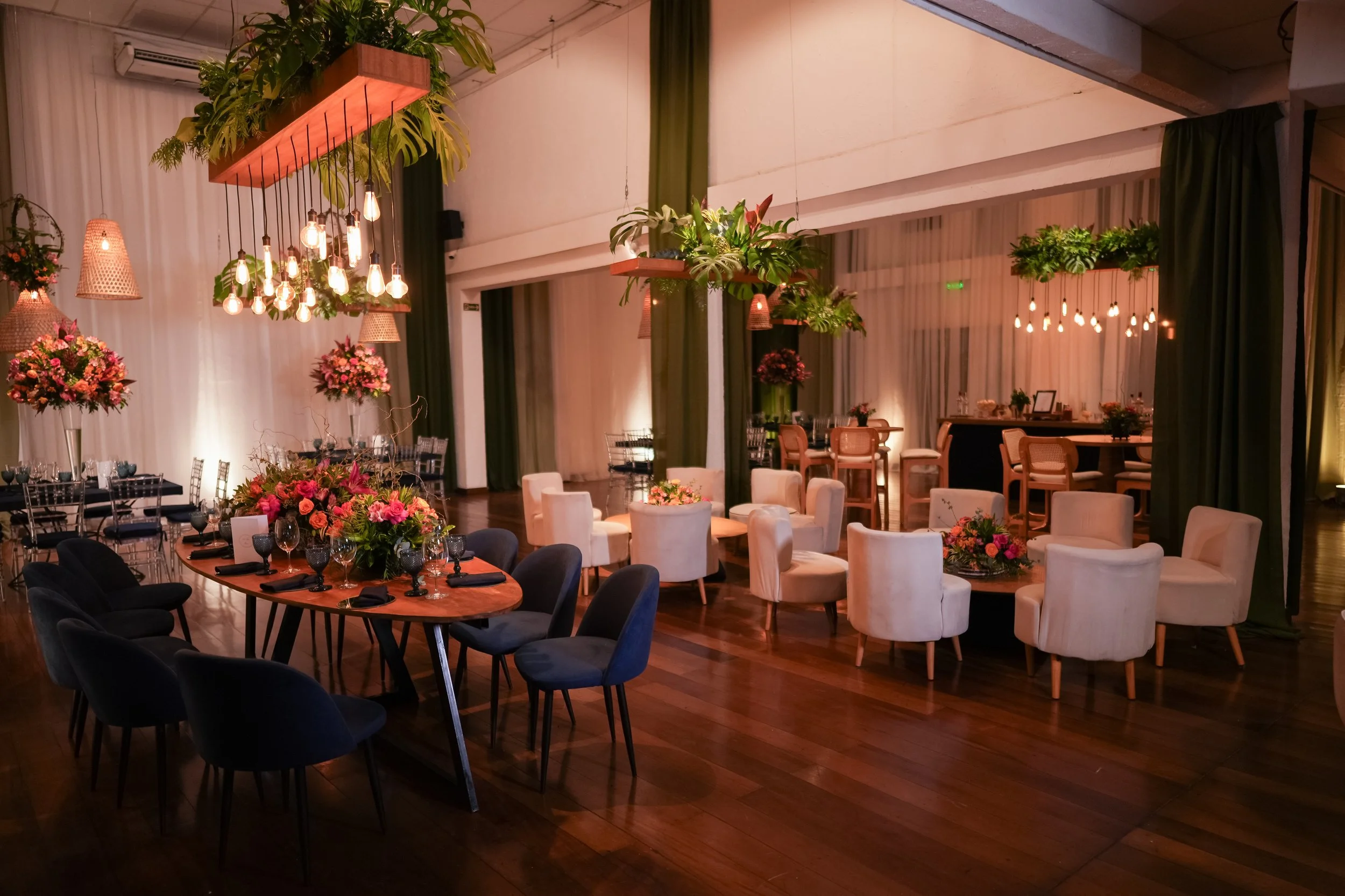 salao principal da spazioitanhanga decorado com mesas de convidados, flores naturais, arranjos aereos e lampadas de filamentos