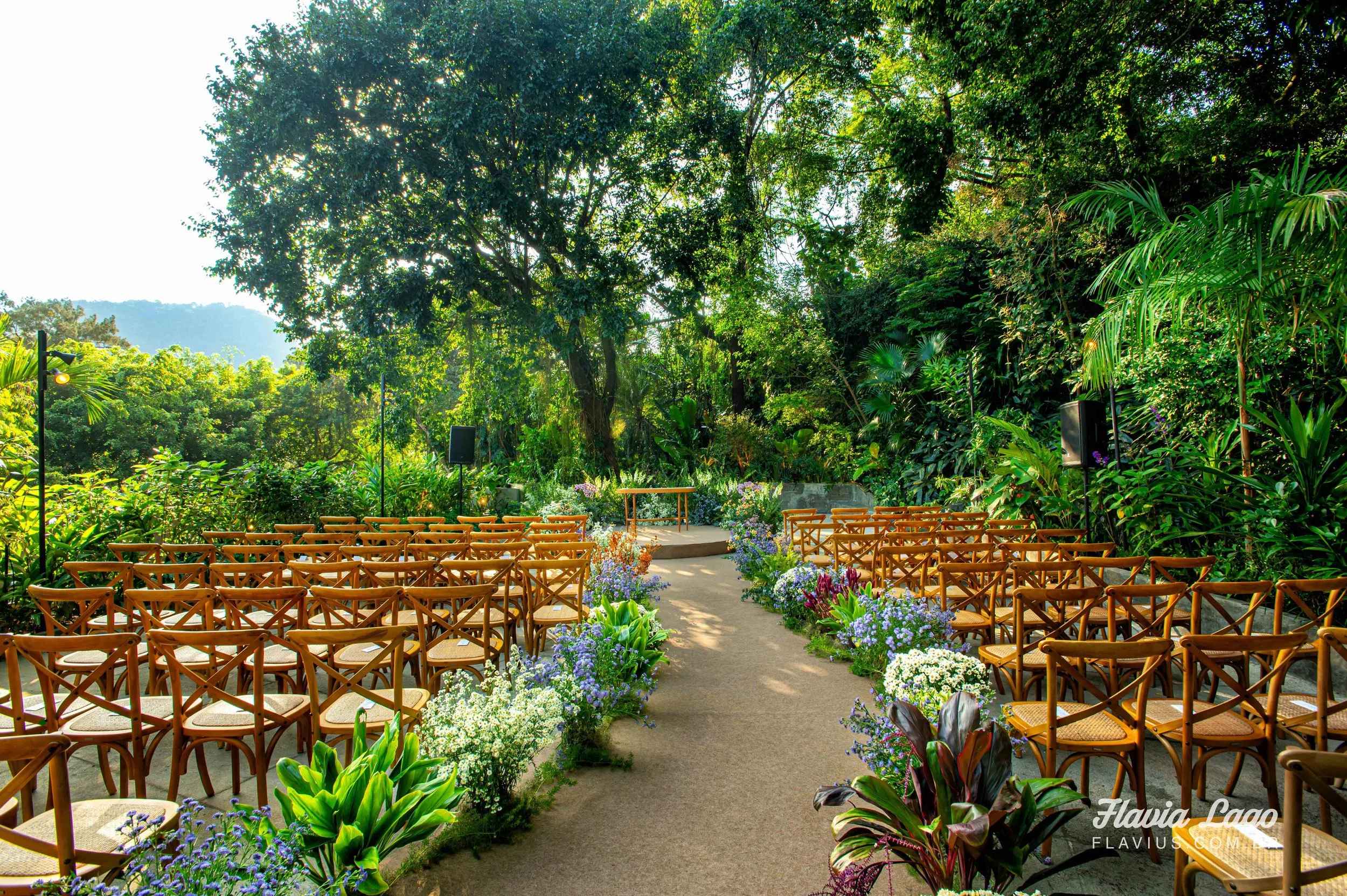 cerimonia de casamento ao ar livre em meio a natureza com cadeiras de madeira e arranjos florais naturais na spazio itnhangá