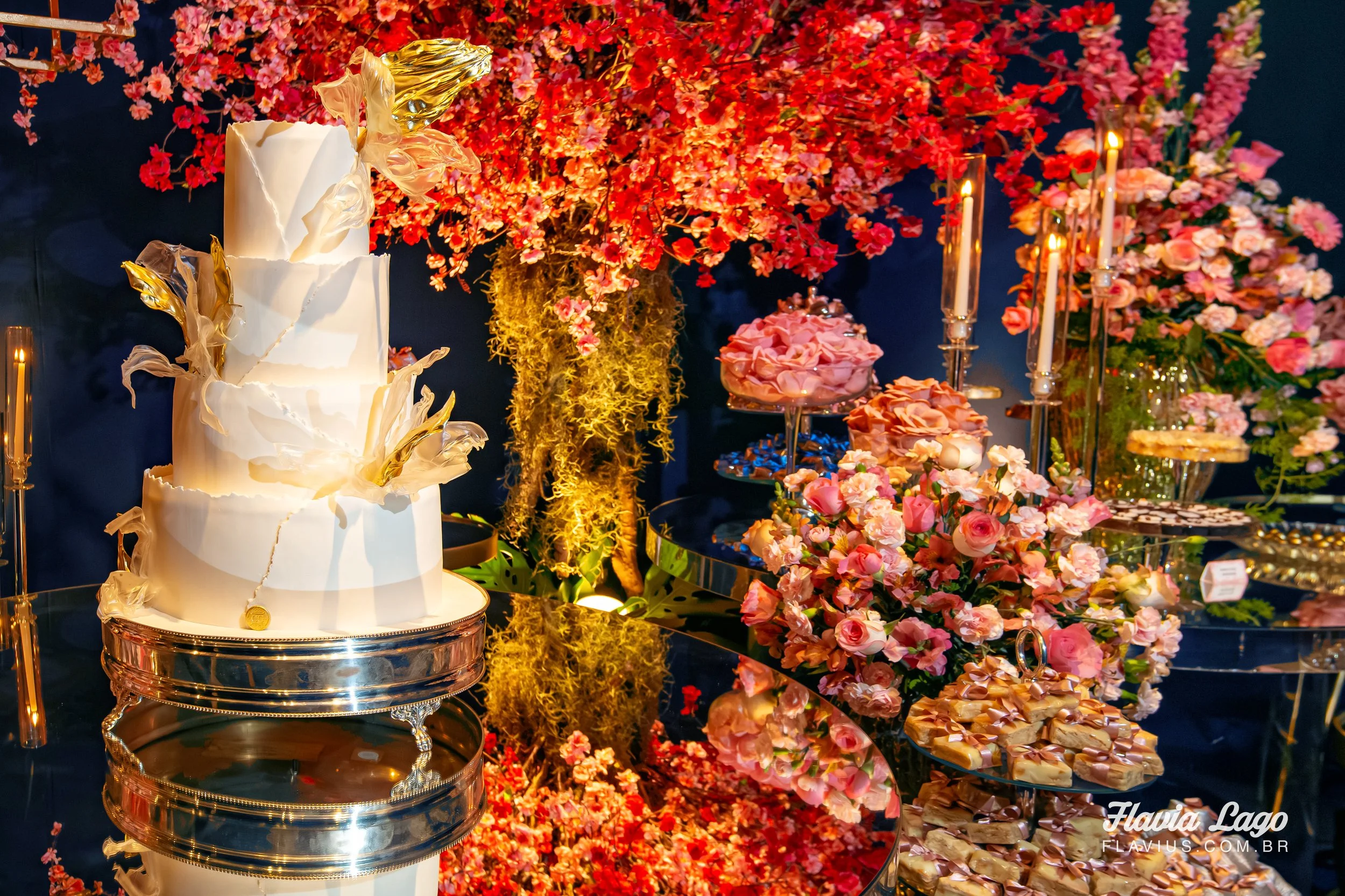 mesa de bolo e doces de festa de 15 anos em azul marinho com flores de cerejeira rosa