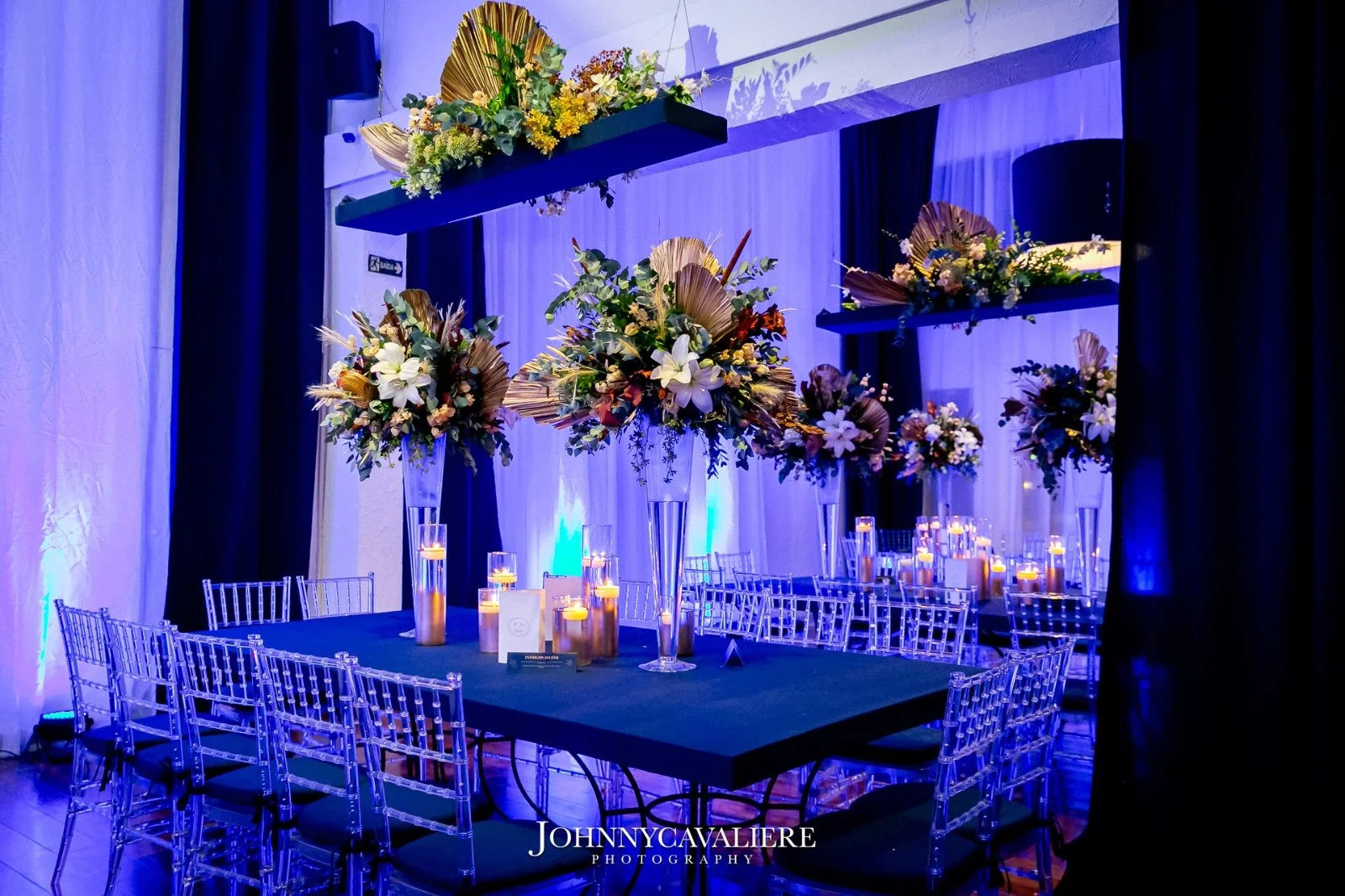 mesas de convidados com arranjos de flores naturais de aniversário azul marinho e dourado