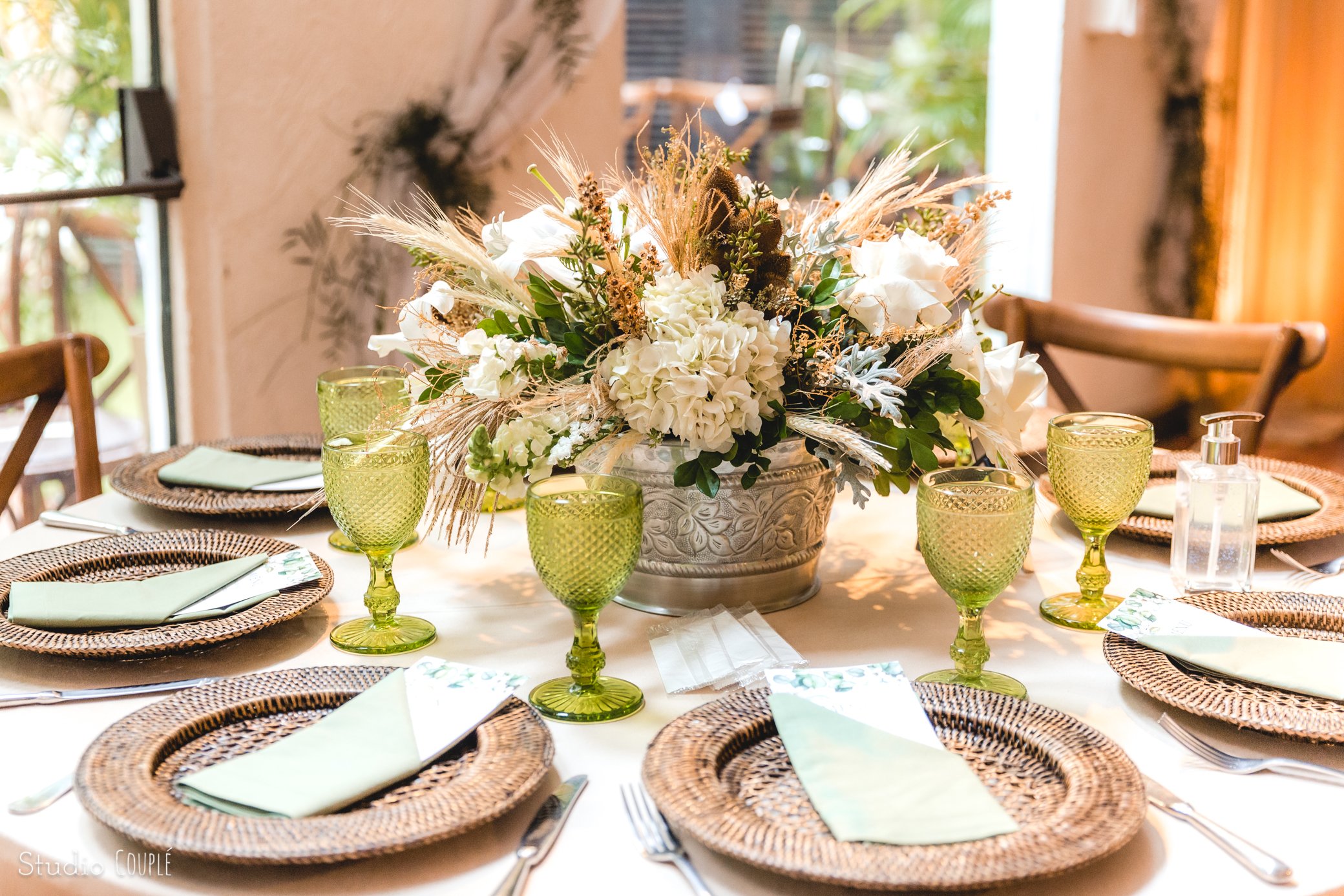 mesa posta de casamento com sousplat taças e arranjo de flores naturais