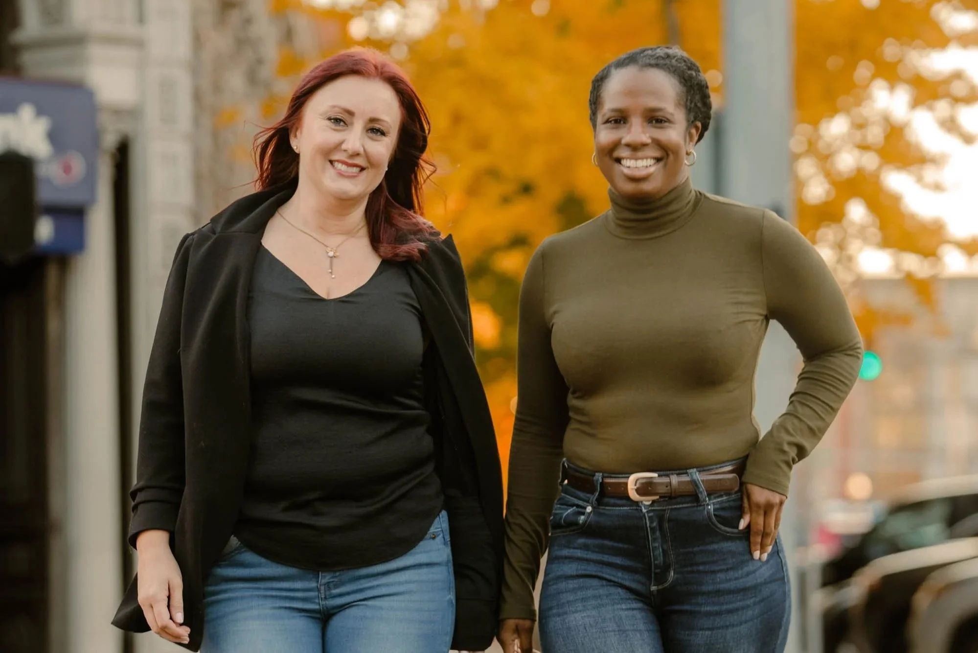 Havenrose Real Estate brokers Katy Voves and Allie Saunders walking confidently toward the camera on a downtown Salem, Oregon street in autumn