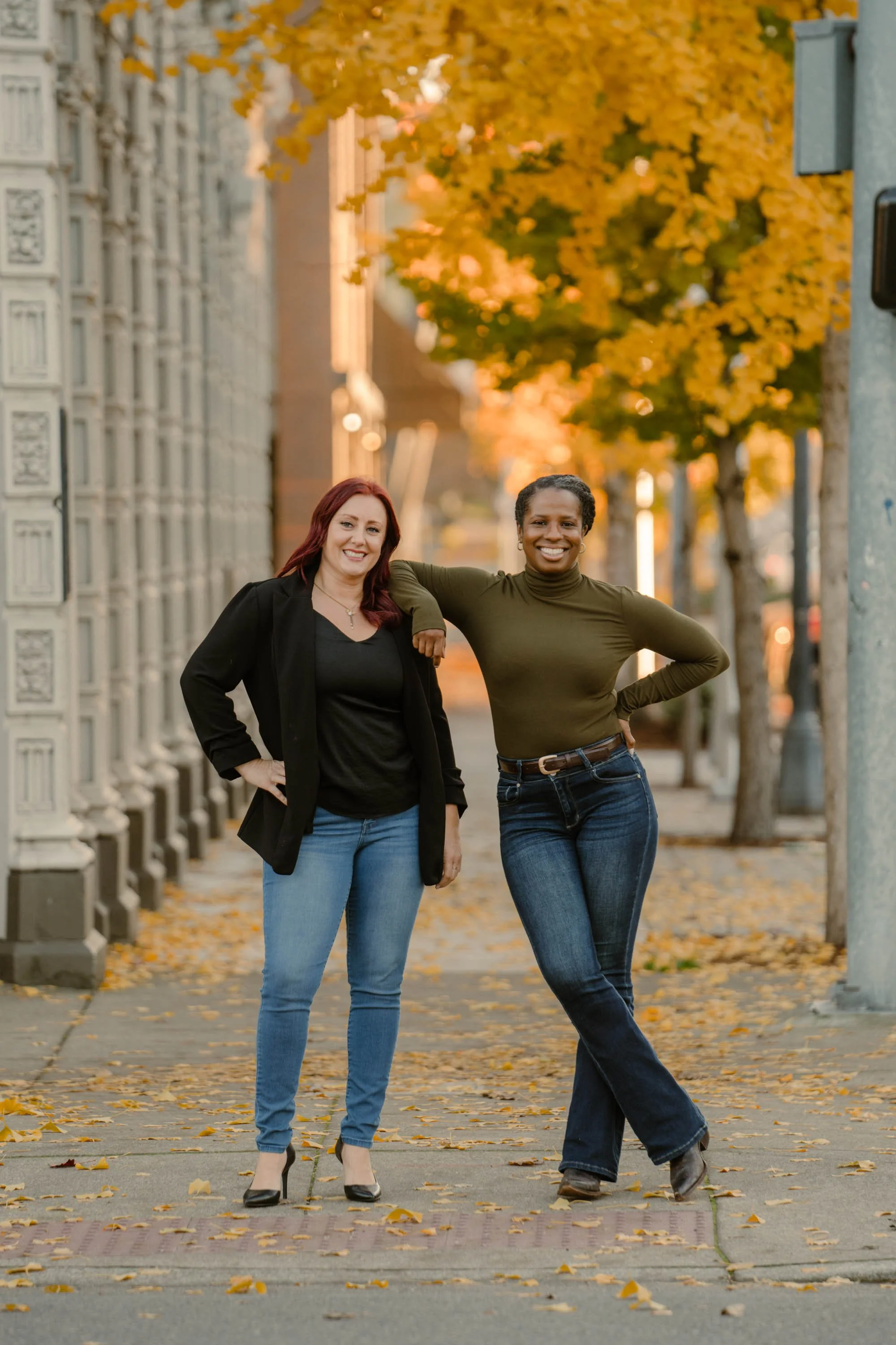 Havenrose Real Estate brokers Katy Voves and Allie Saunders standing together on a downtown Salem, Oregon street lined with golden fall trees