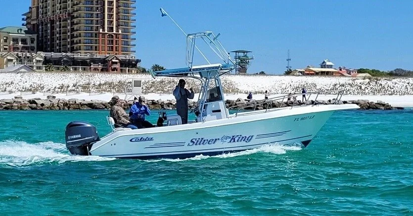 destin fishing boat leaving the pass with happy customers