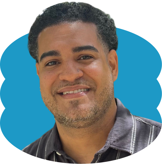 Daniel Morales Armstrong smiling with short, curly dark hair and a light beard, wearing a dark striped shirt, placed over a scalloped blue oval shape.