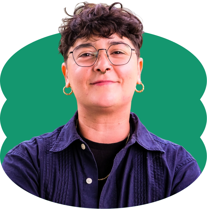 Kari Claudio Betancourt smiling with short wavy hair, wearing glasses, violet button-down collared shirt over a black shirt, placed over a scalloped green oval shape.