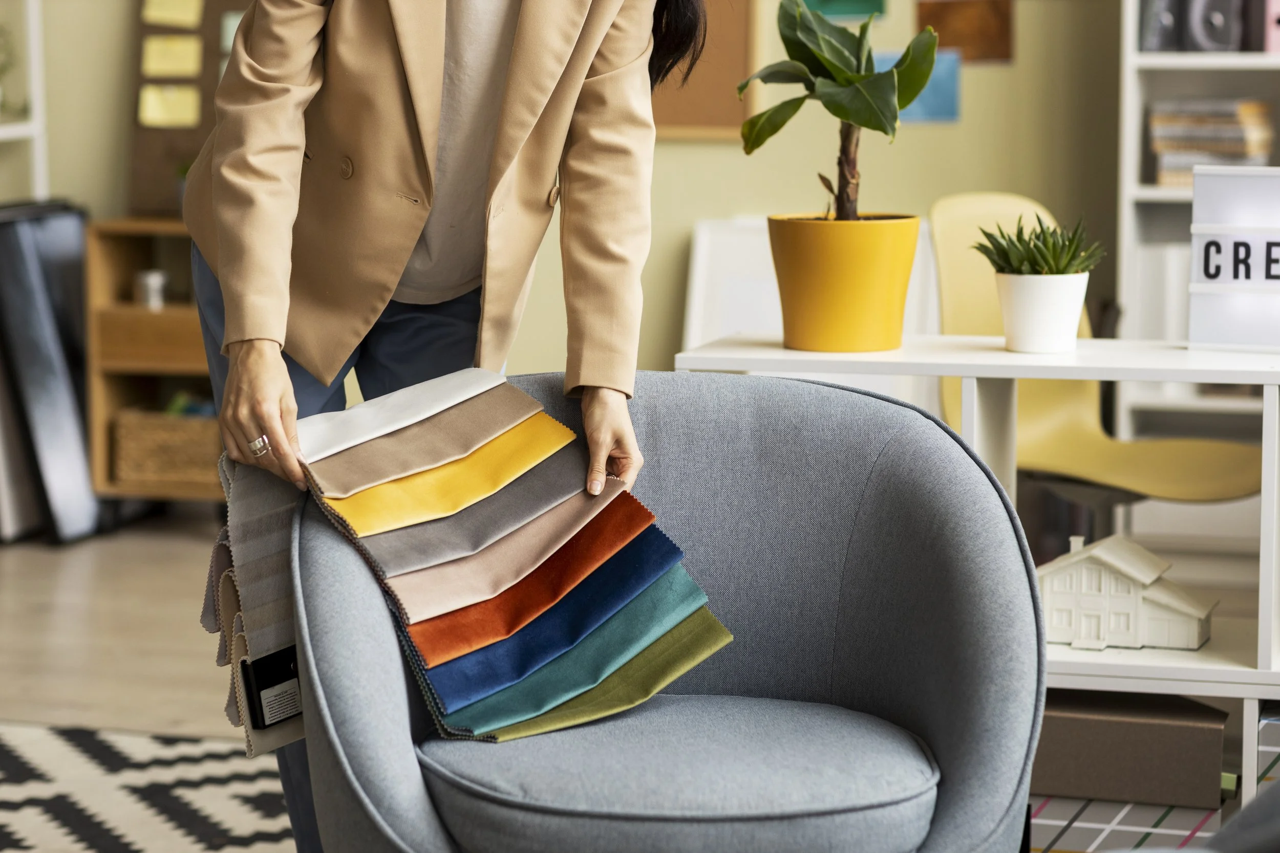 Person selecting fabric swatches in an interior design office.