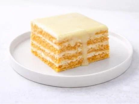 Layered orange cake with cream filling, topped with orange icing.