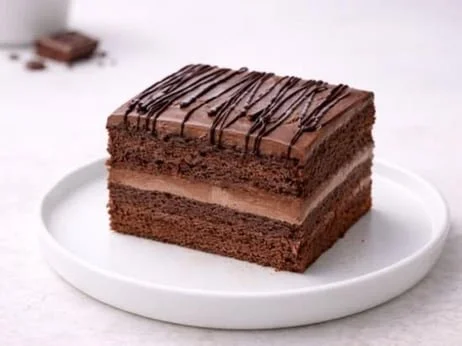 Chocolate sponge layers, chocolate cream filling, and chocolate frosting with drizzle.