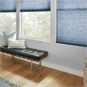 Interior with a wooden bench, pillows, and blue window blinds in a room with hardwood flooring.