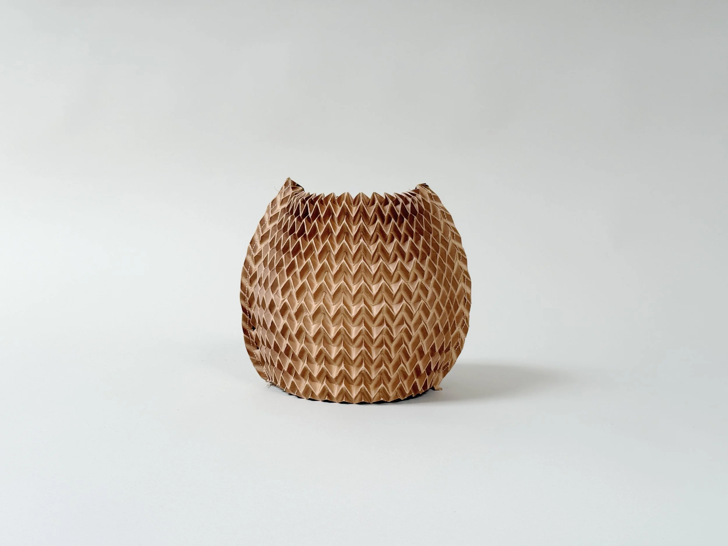 Single small bubble Pleated Paper Vase Sleeve by Kept LA in  warm brown tone, solo product shot showing rounded form and  irregular top edge
