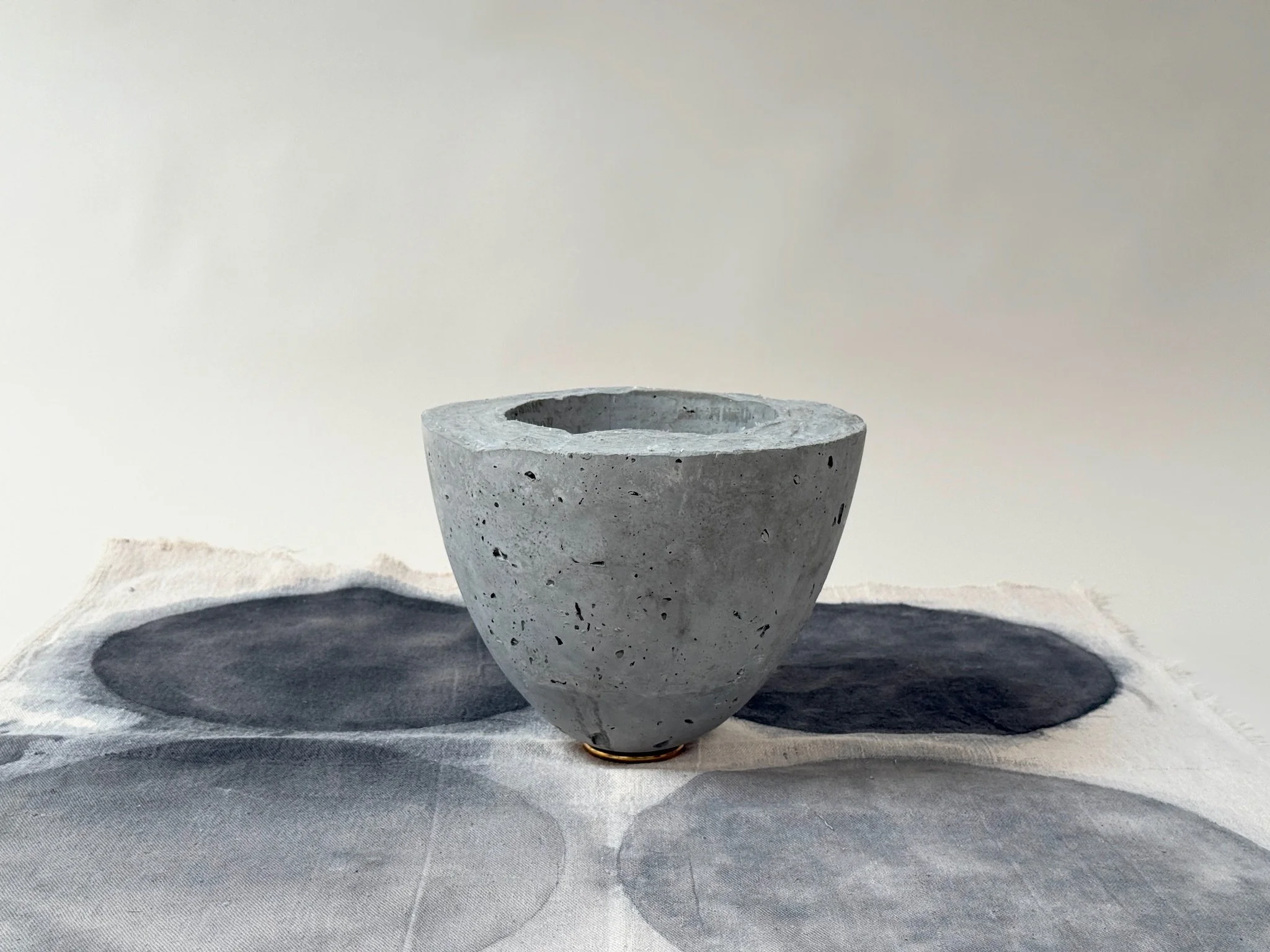 Single Vaultic cast concrete vessel by Kept LA shown with custom painted table linen