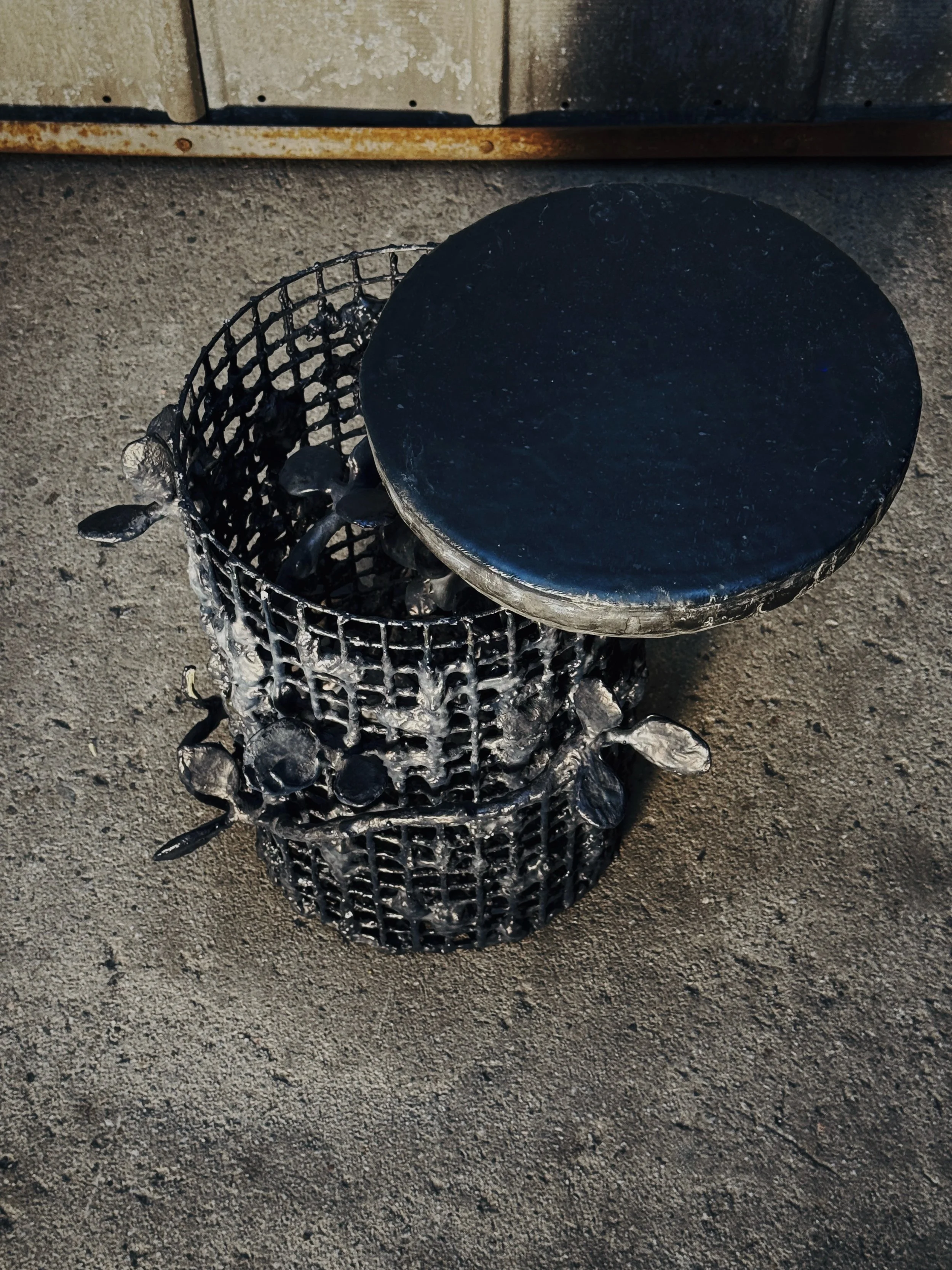 Built on a steel grid body, this side table/stool holds a world inside it. Wire and clay vines and leaves grow through the structure &mdash; outward and inward &mdash; and beneath the removable top, small, birds hide as if nest-building or sleeping i