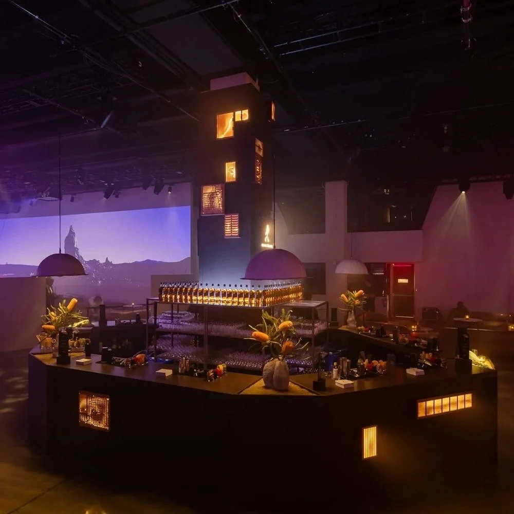 Custom-made, with circular design as a core driver.

This custom bar environment for up to 12 bartenders &mdash; six-sided, engineered around a venue column, upcycled copper lighting, hand-sculpted plaster pendants, corner planter boxes, branded prod