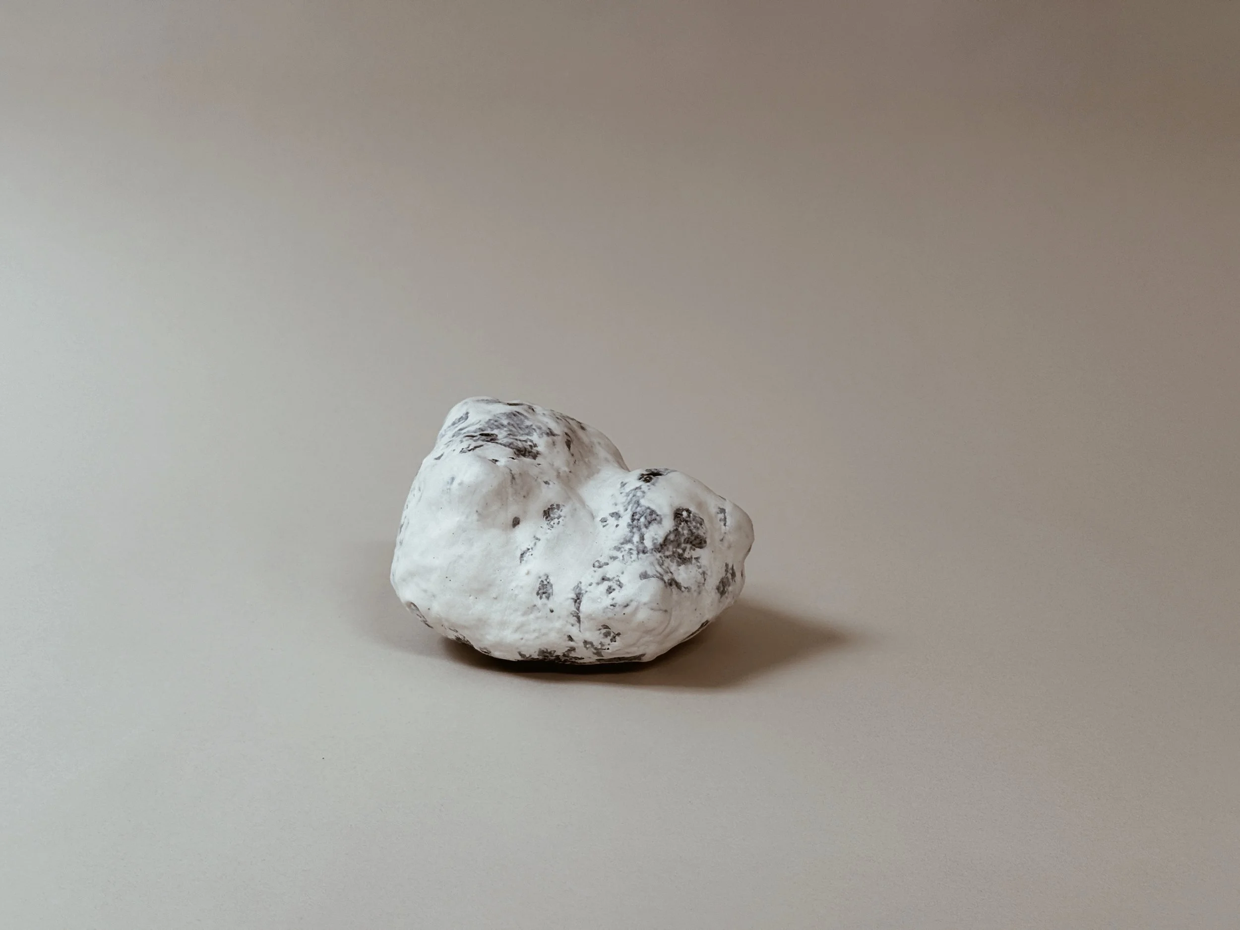 Bone white Specimen Display Rock by Kept LA solo product shot  showing soft white ceramic-like glaze with deep blue undertones  and naturally varied surface texture
