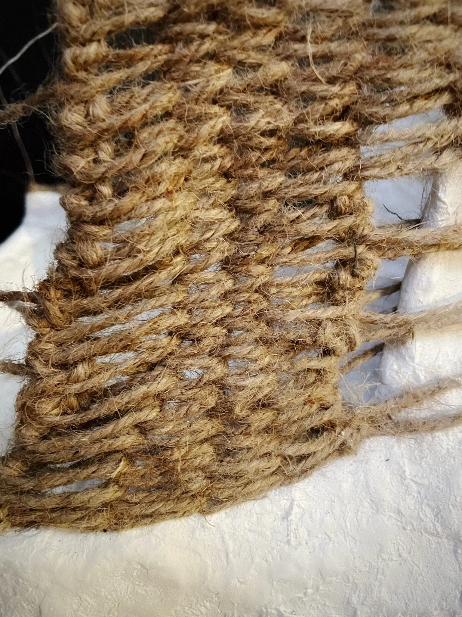 Extreme close detail of jute rope weave texture on Weave and  Plaster Basket by Kept LA showing handmade fiber construction  against plaster base
