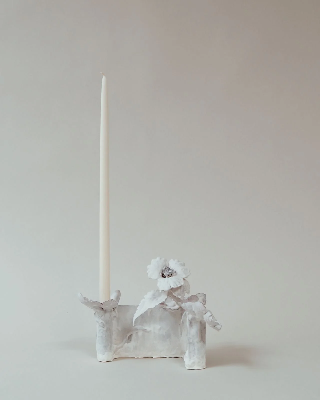 Single hand-cast gypsum tole candleholder with sculptural flower forms and white taper candle — artisanal decor object Kept Workshop Los Angeles
