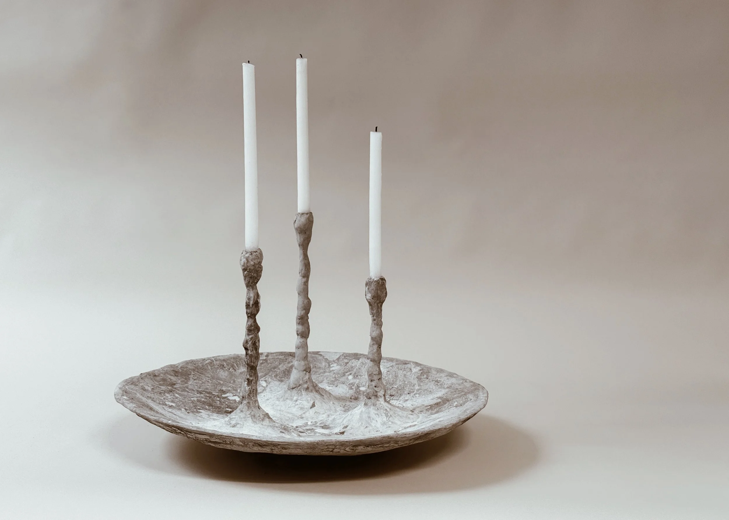 Alberto Concrete Bowl with Candlesticks by Kept LA showing  oversized hand-laid concrete shallow bowl with three integrated  varied-height candlesticks holding white taper candles, front view
