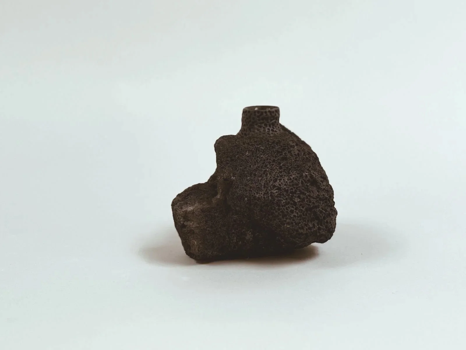 Three-quarter view of Volcanic Candlestick by Kept LA in locally  sourced lava stone showing full sculptural form and naturally  varied surface texture