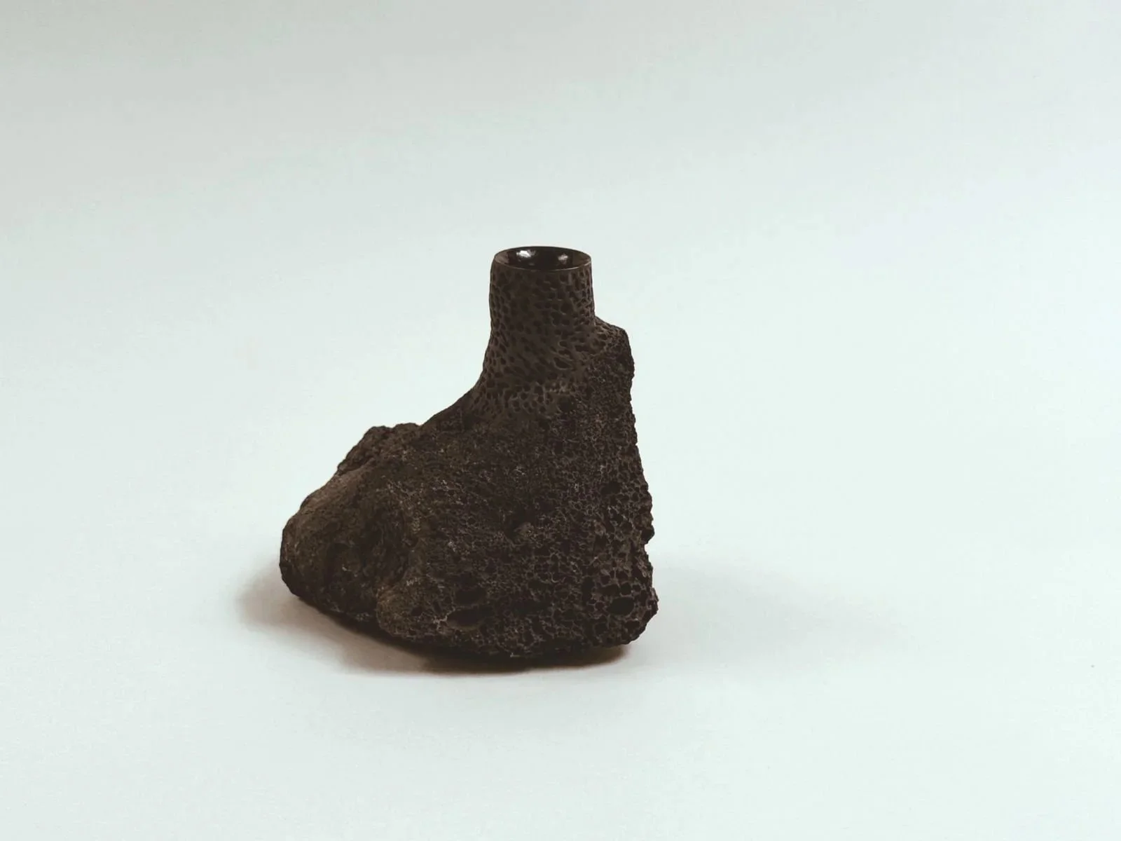 Front product shot of single Volcanic Candlestick by Kept LA  in locally sourced lava stone showing taper hole opening and  irregular base form