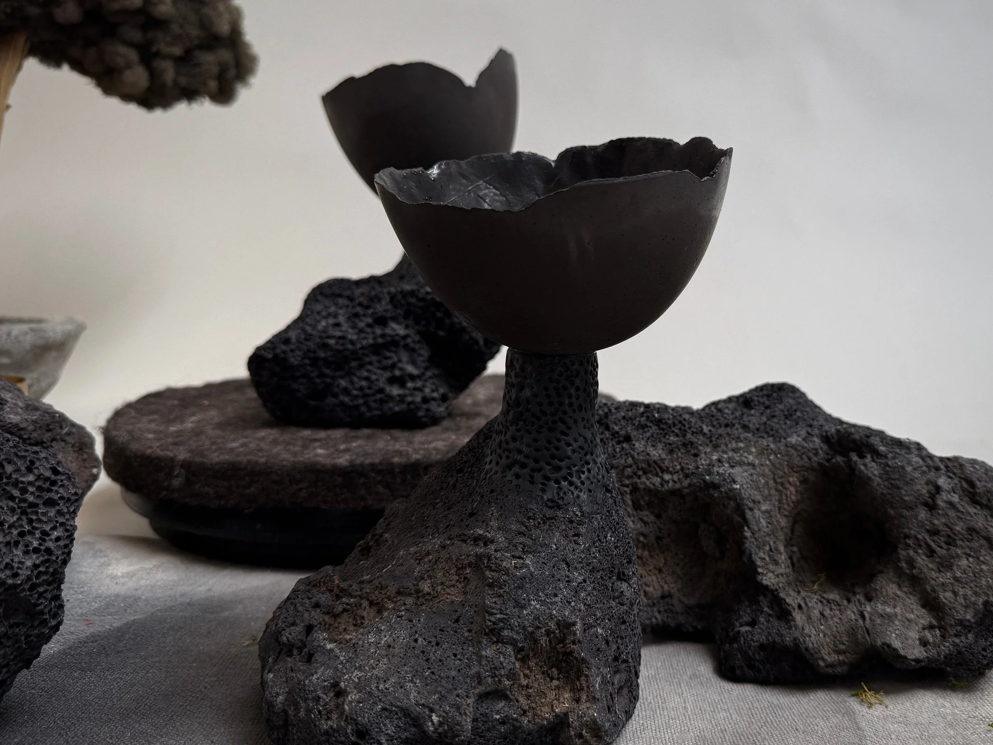 Volcanic Candlestick by Kept LA with Little Cup insert holding  botanicals, shown in styled landscape grouping with additional  lava stone pieces