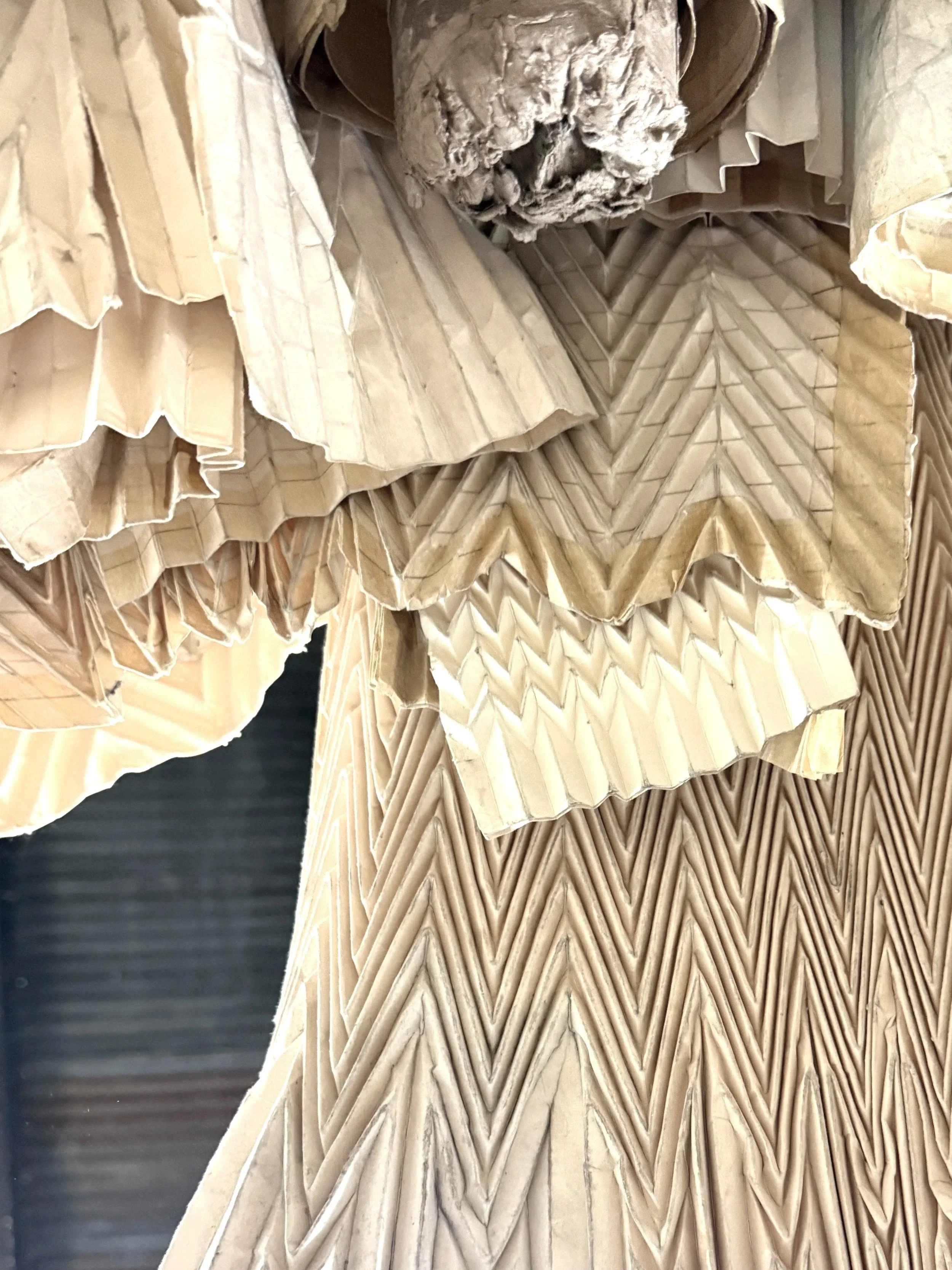 Close detail of stacked retired fashion industry pleating forms  used to make Kept LA Pleated Paper Vase Sleeves showing source  material texture and varied patterns before construction