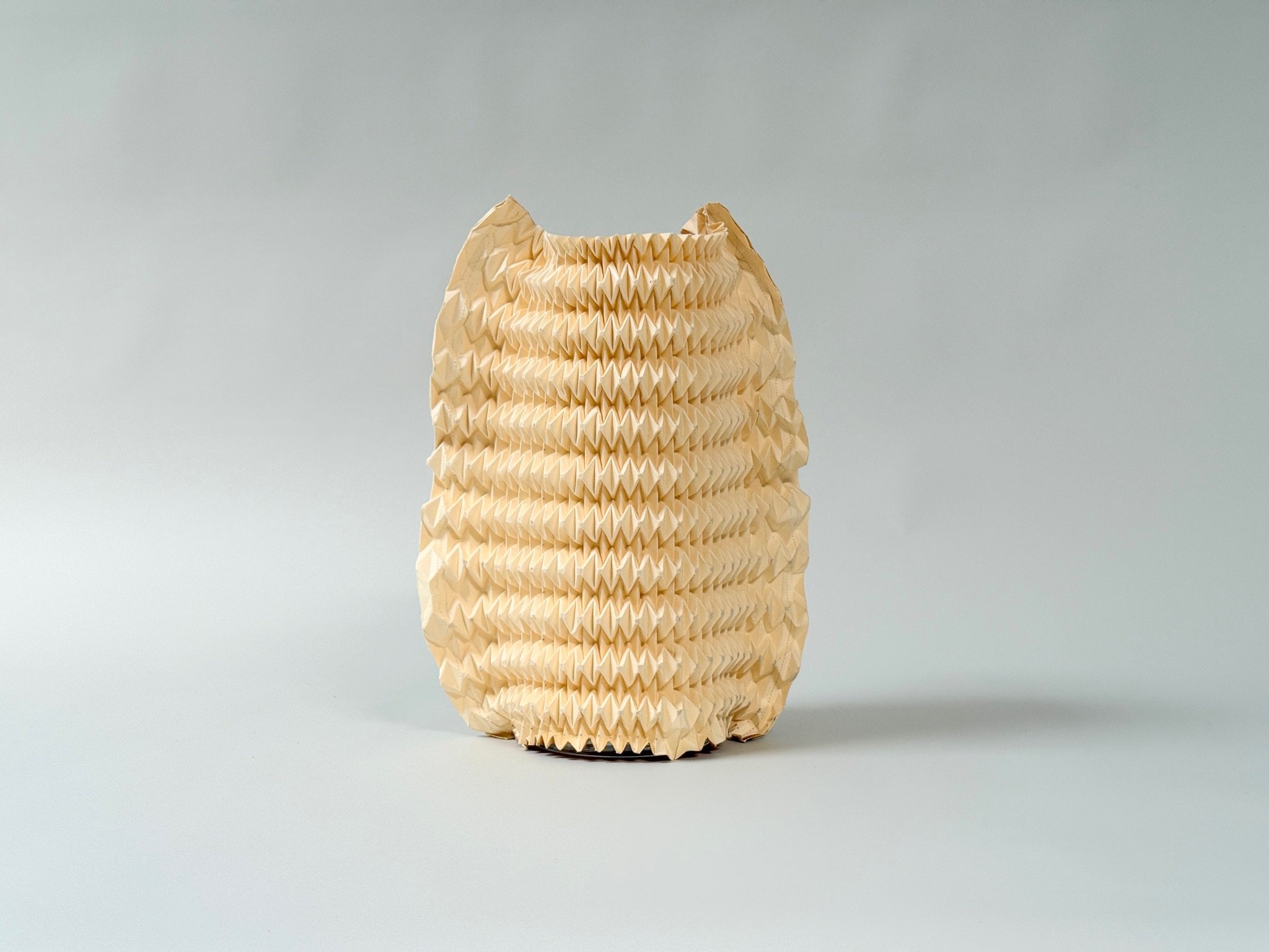 Pleated Paper Vase Sleeves by Kept LA in natural and warm  tones side by side showing variation in pattern and color between  individual pieces made from retired pleating forms