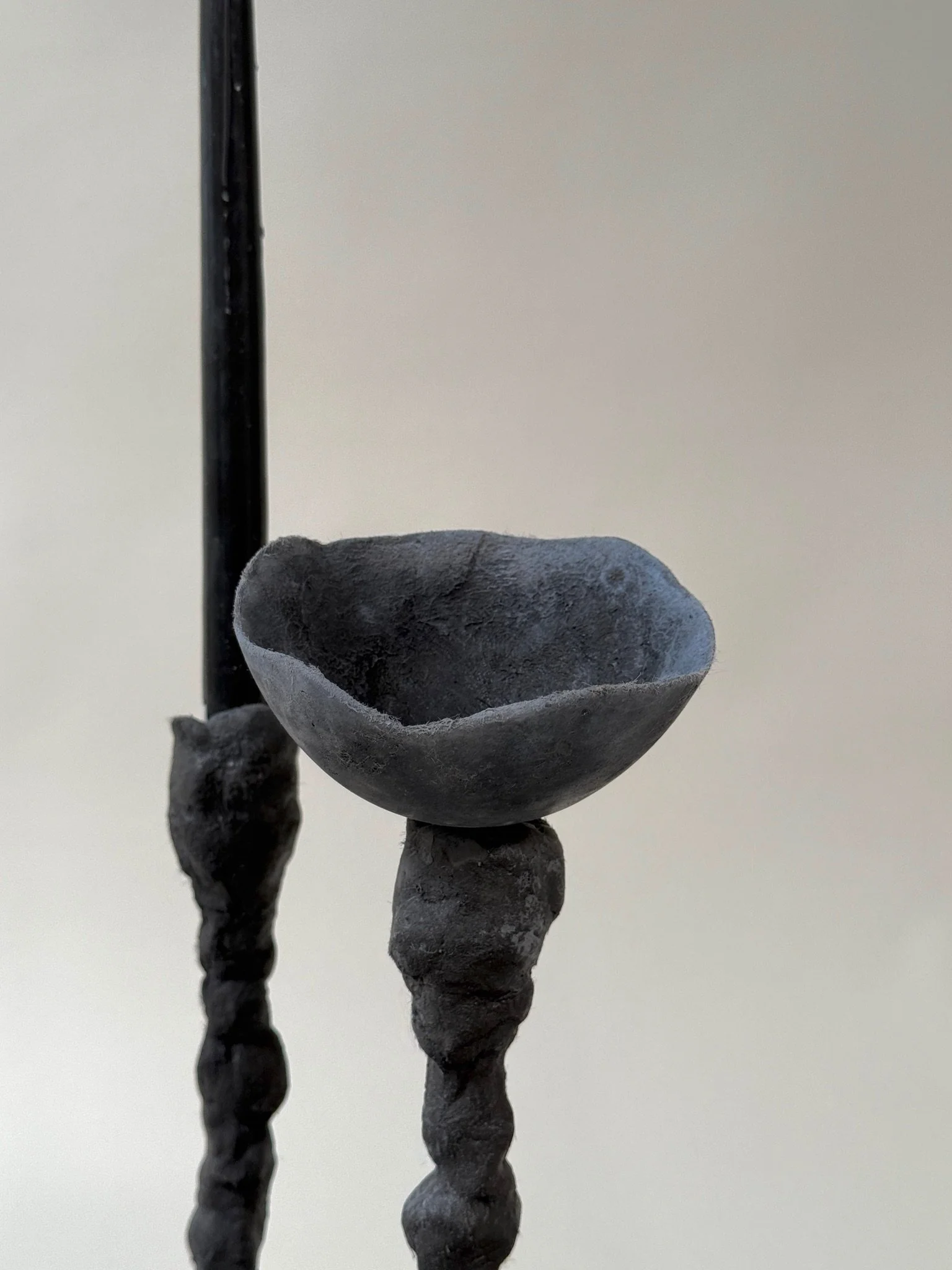 Close detail of Alberto Candlestick stem by Kept LA showing  hand-sculpted black concrete texture with grey Little Cup insert,  side view