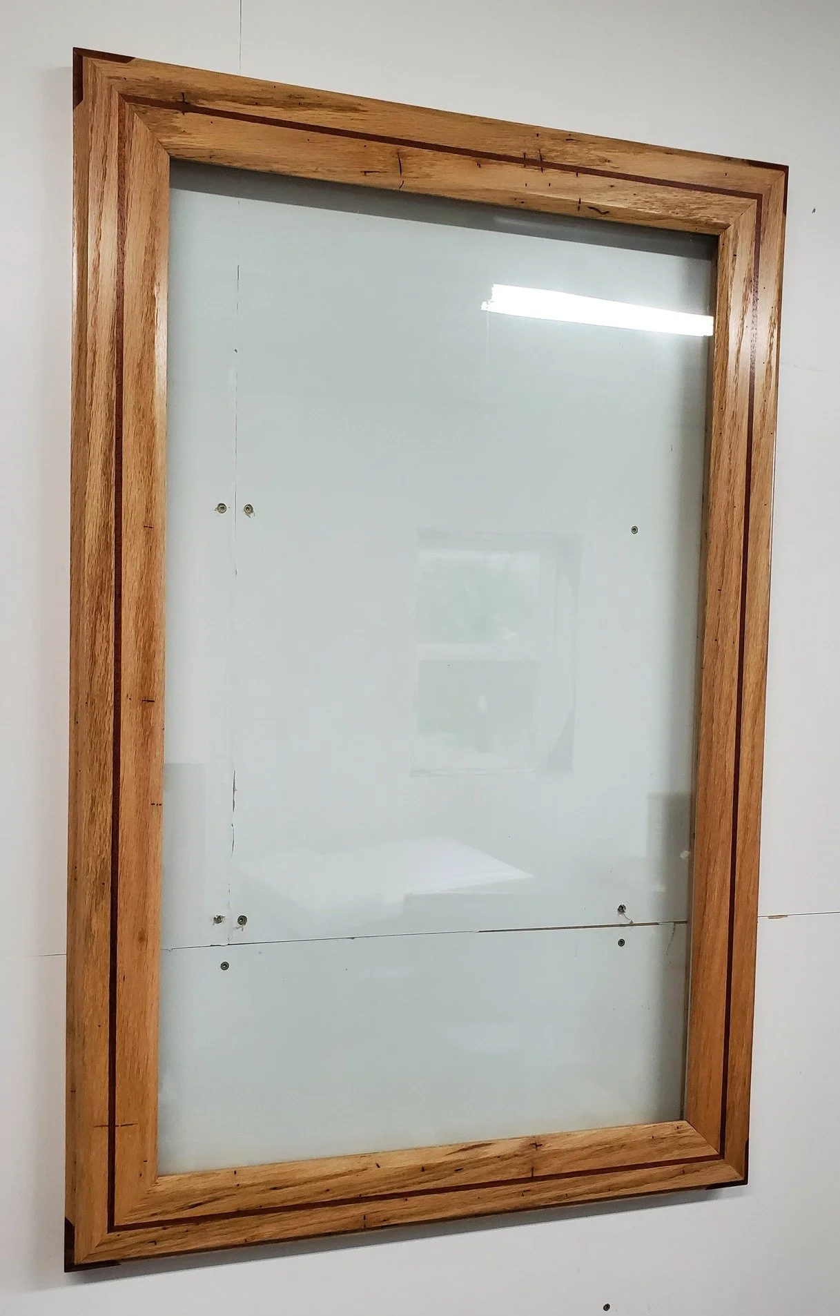 I was asked to make a large frame to fit this piece of glass. It measures around 30"x42 and it is heavy! Made from wormy red oak and Brazilian cherry for the accent line and the splines in the corners.
