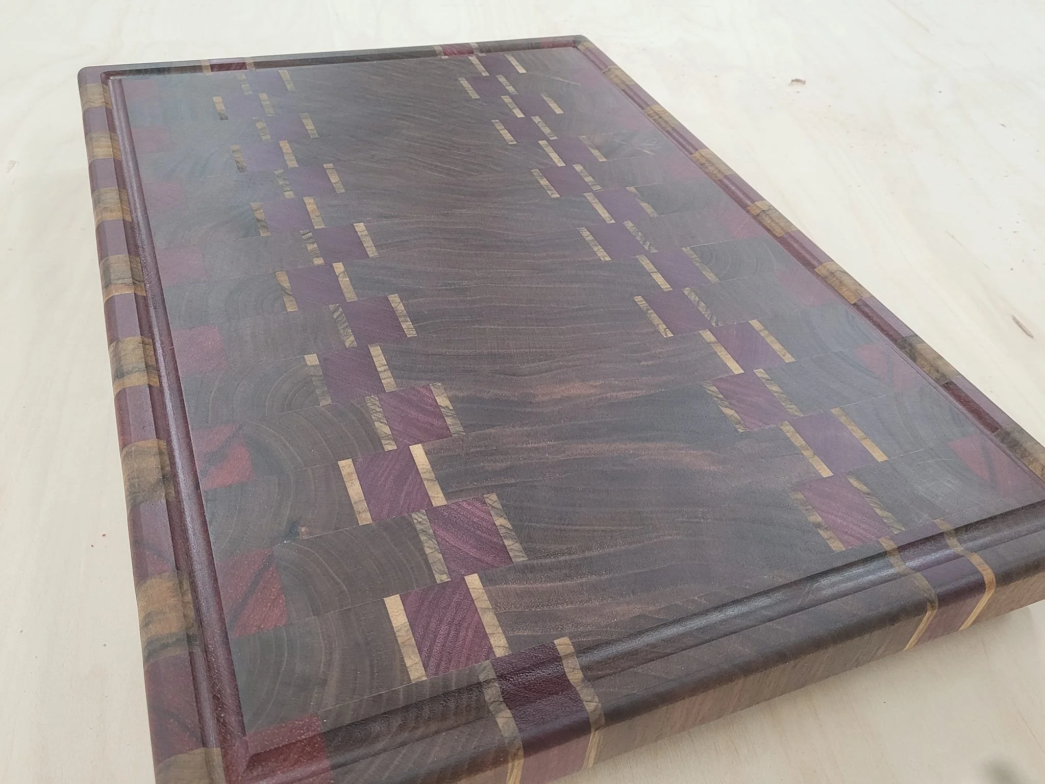 Endgrain cutting board made from walnut, purple heart, padauk and black limba
