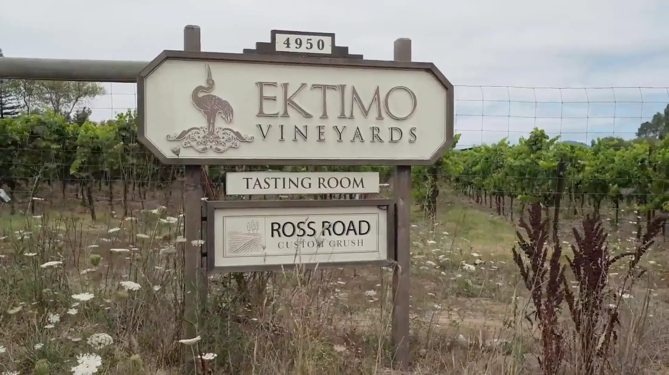 Sign for Ektimo Vineyards with a logo of a flamingo, indicating a tasting room on Ross Road.