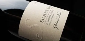 Close-up of a wine bottle with a beige label displaying the brand name 'Scherer' and other details.