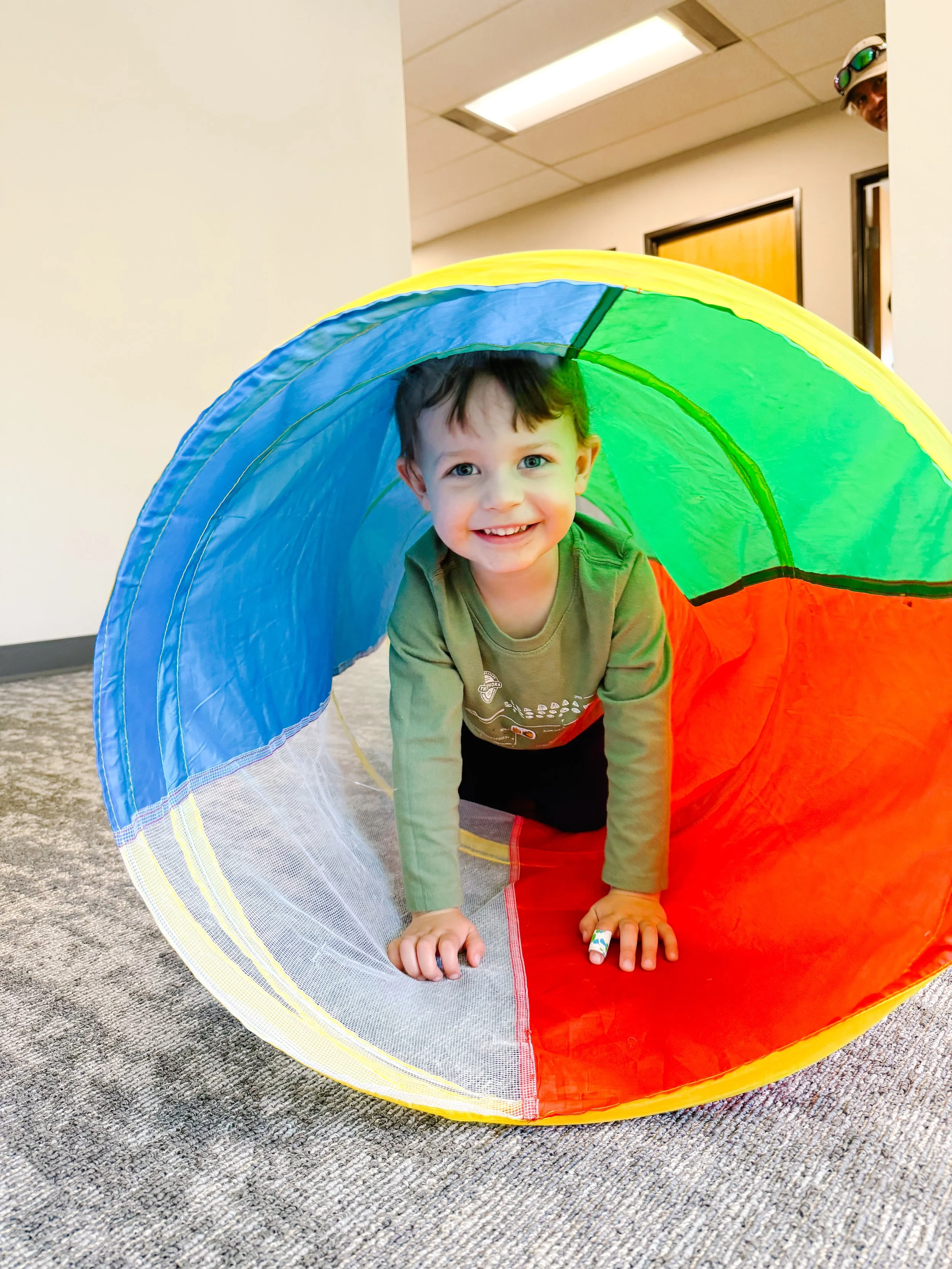 boy crawling through play tunnel