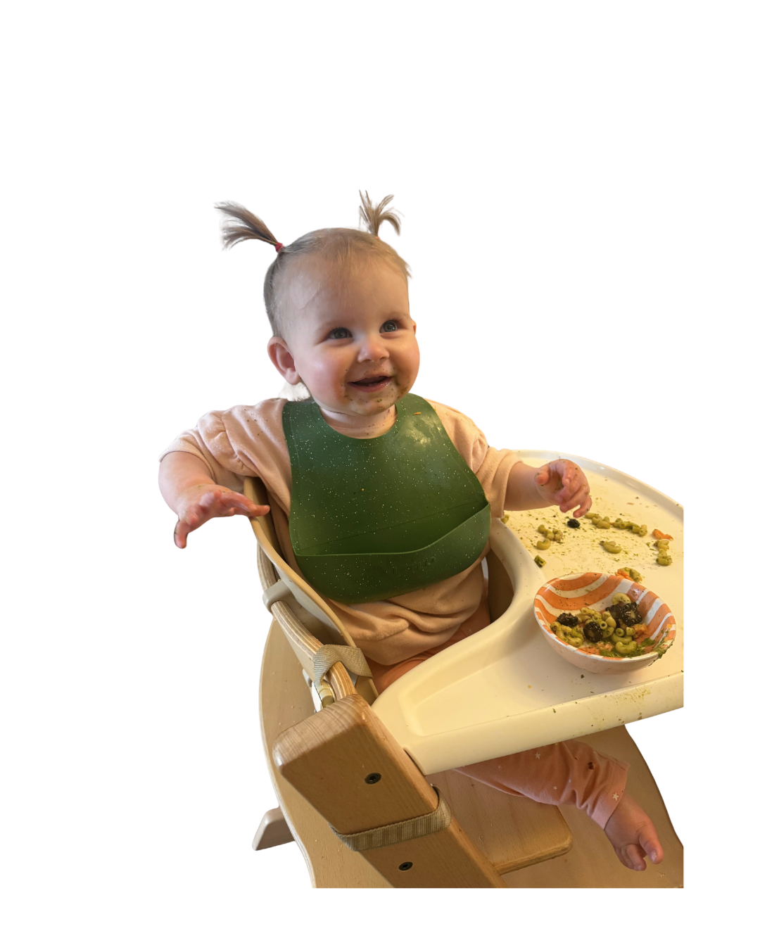 girl sitting in high chair with bib and smiling