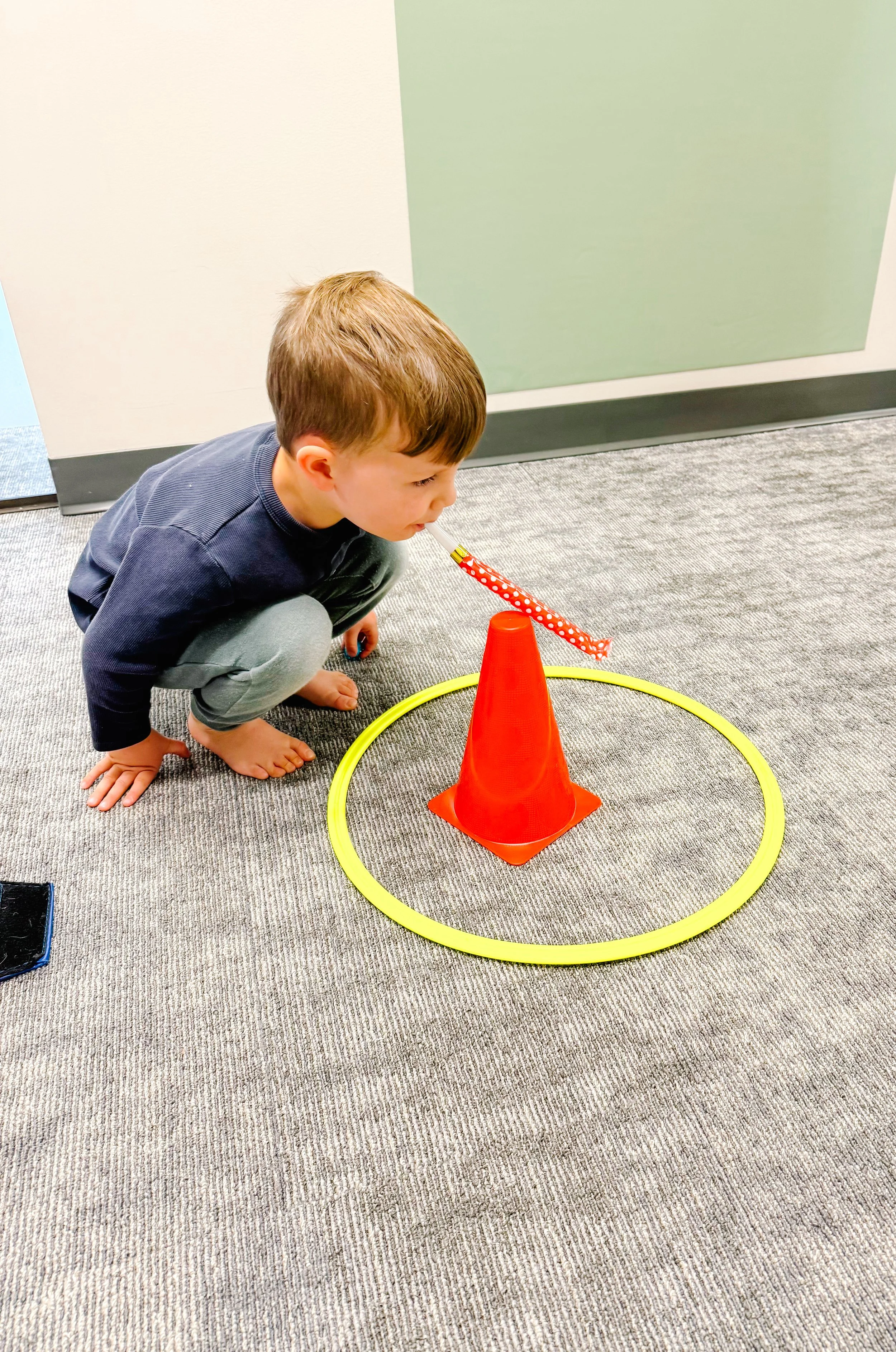 kid squatting and blowing party blower
