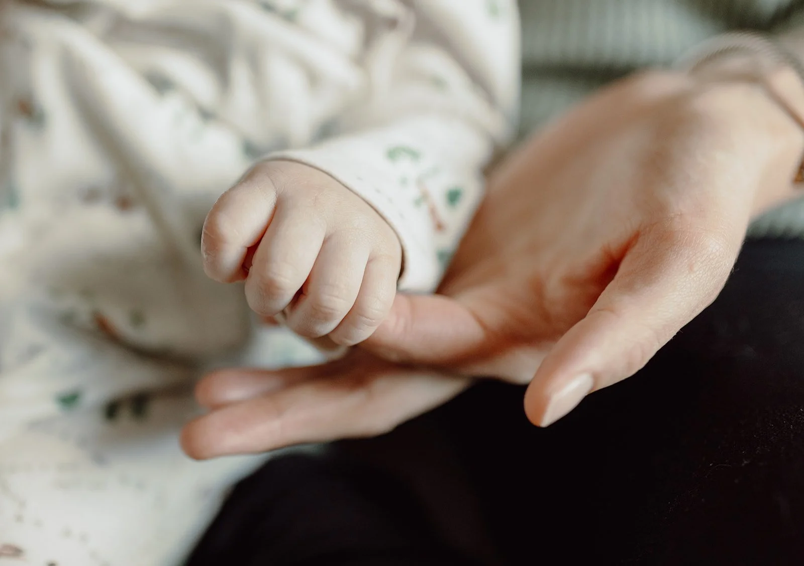 baby holding mother finger