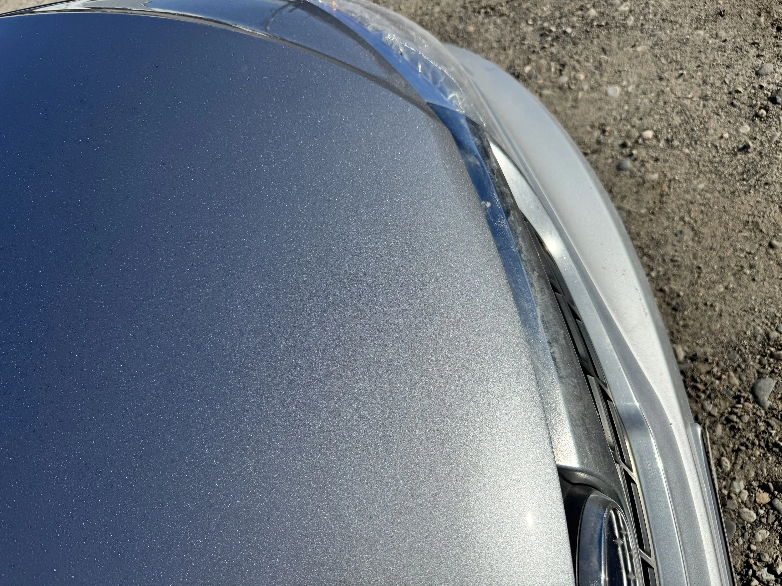 Silver car with the hood repaired and refinished.