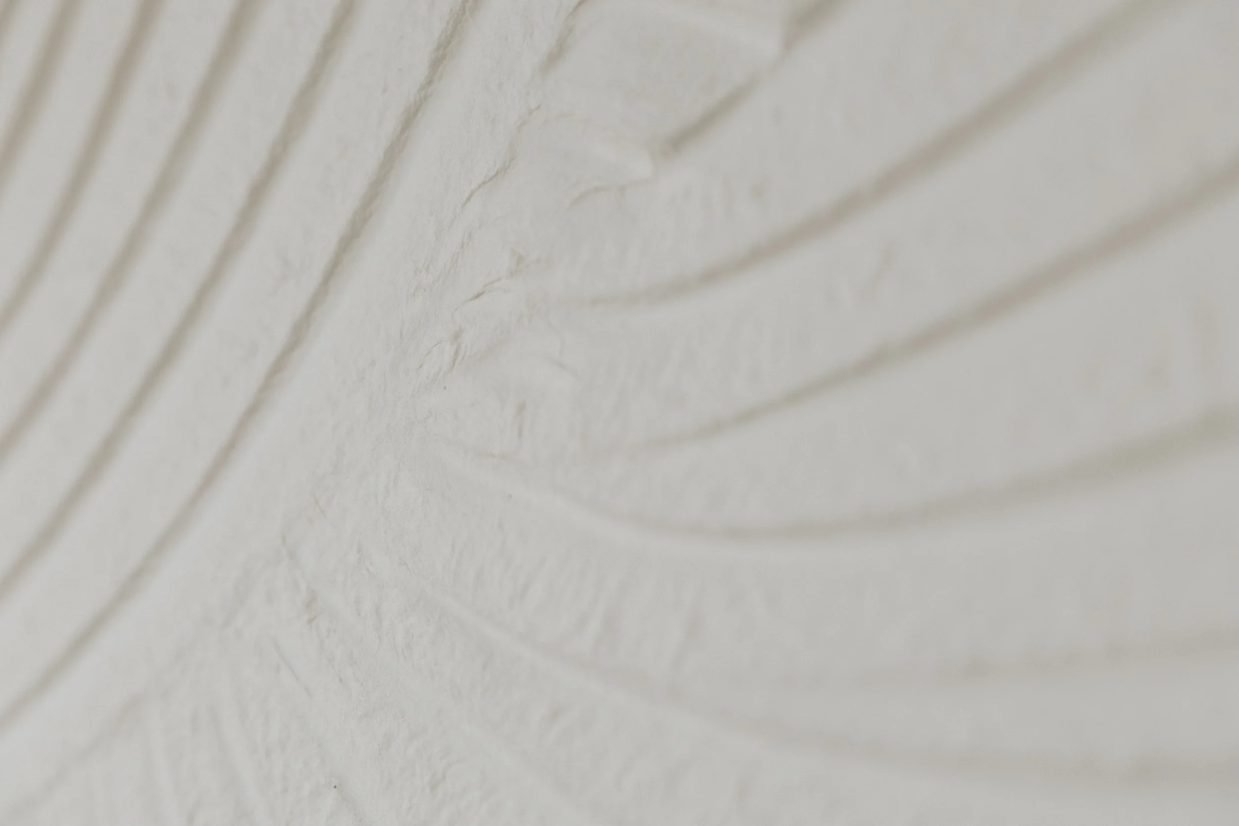 Close-up of a white wall with diagonal grooves.