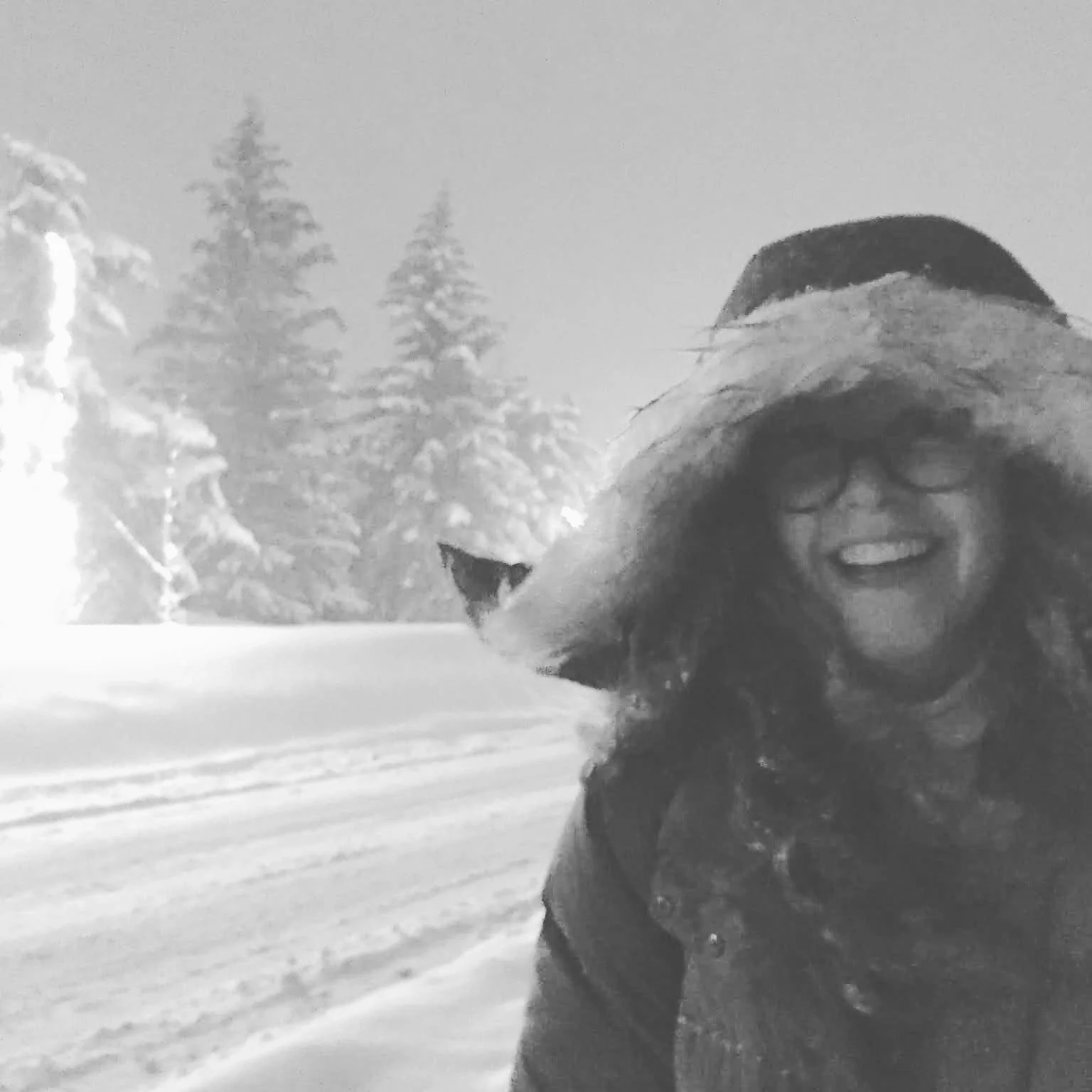 Kerry wearing a big smile and winter parka walking a road in a snowstorm.